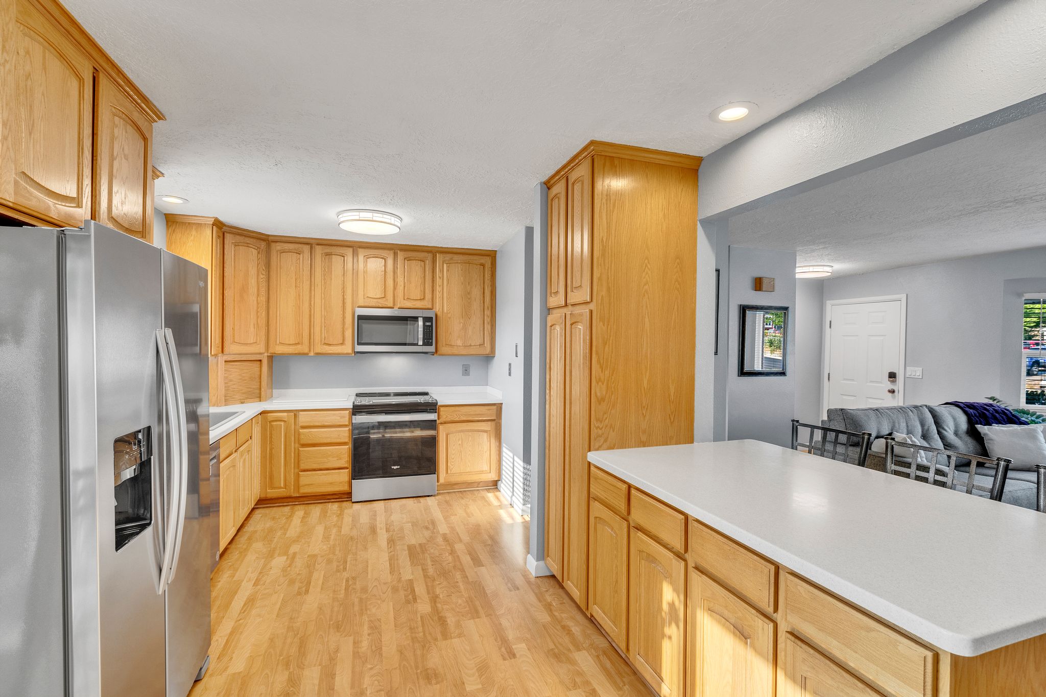 Kitchen featuring wood-finish cabinetry, stainless steel appliances, and solid surface countertops