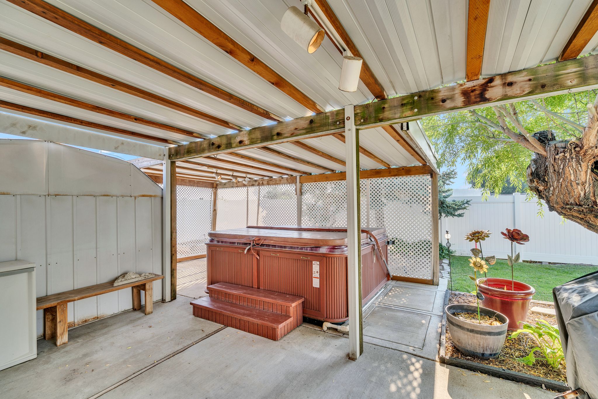Covered patio featuring a hot tub with wood-finish steps