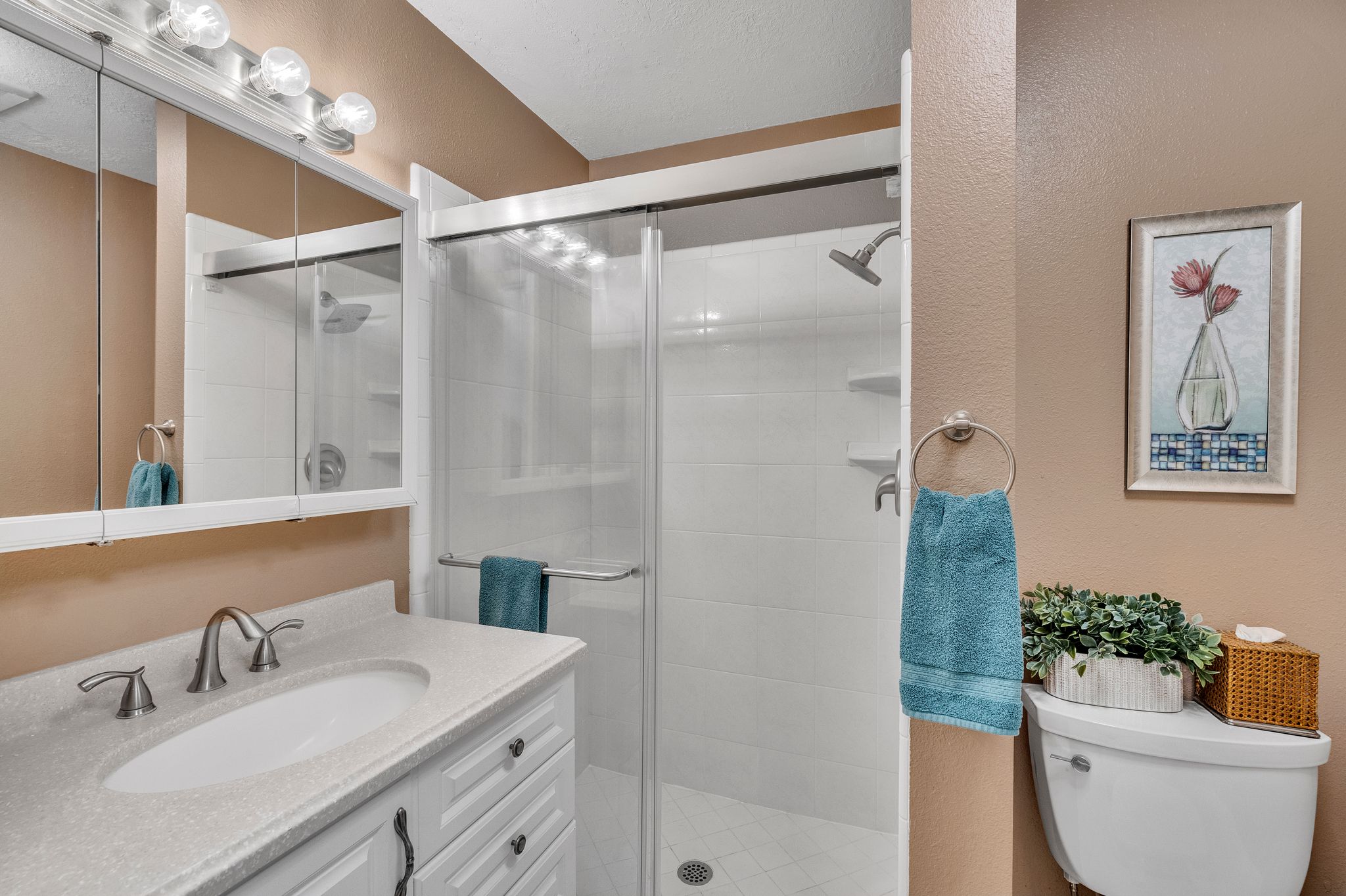 Bathroom featuring a white vanity with an integrated sink, brushed nickel faucet, and a large wall-mounted mirror