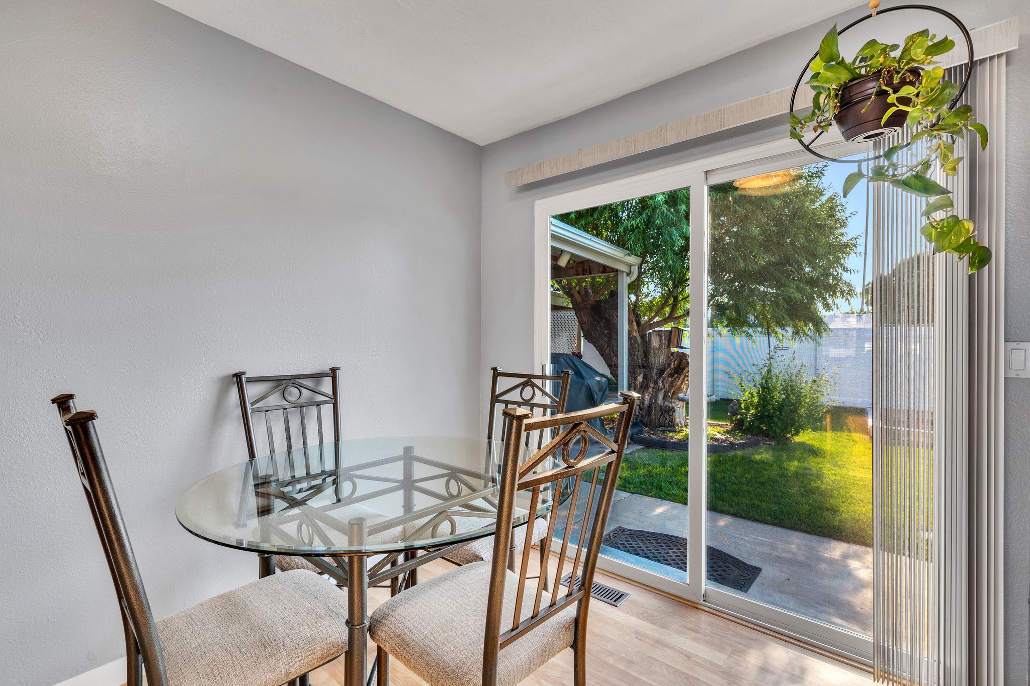 Sliding glass door opening to an outdoor patio and green space