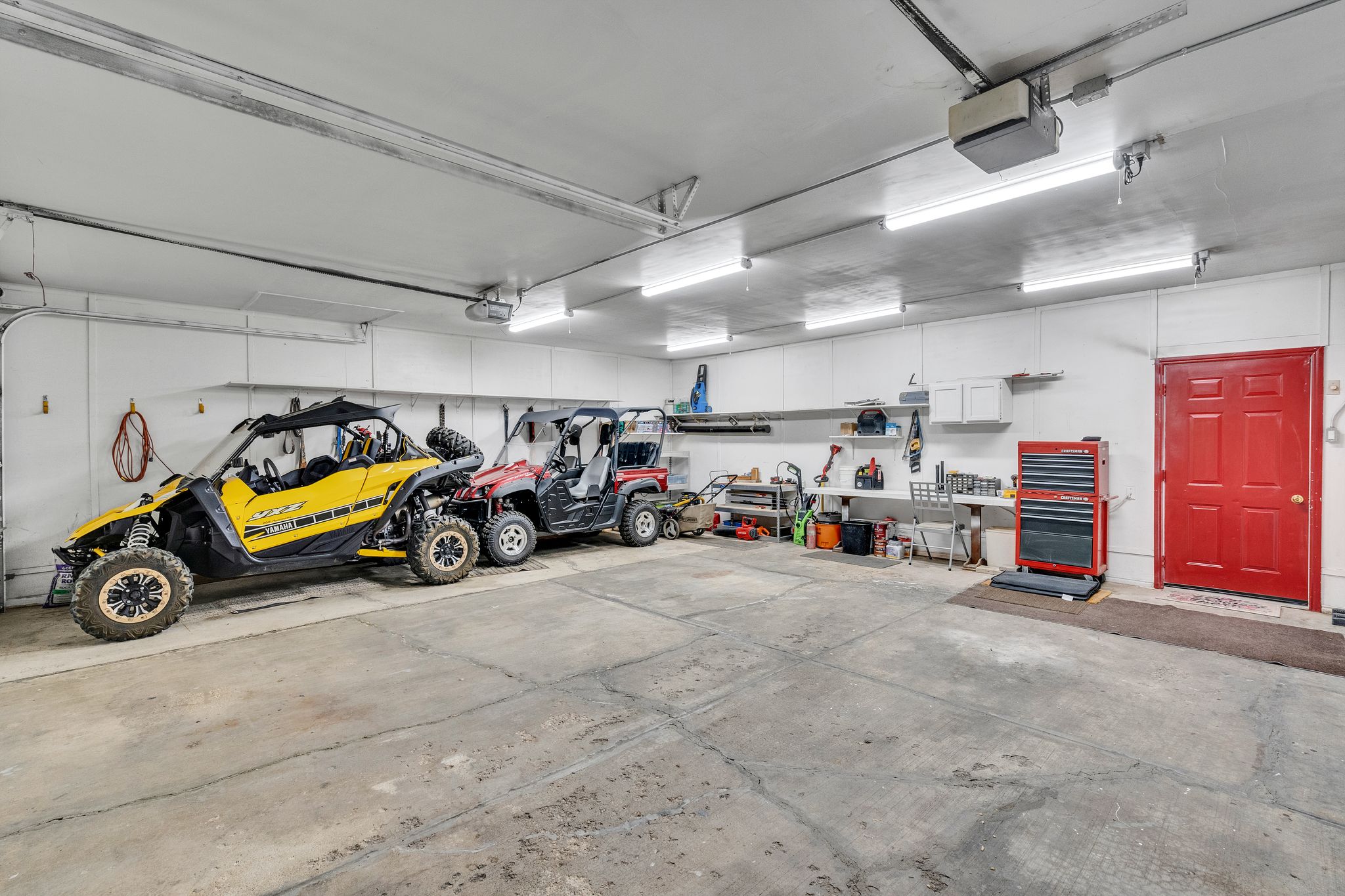 Spacious garage featuring concrete flooring and white paneled walls