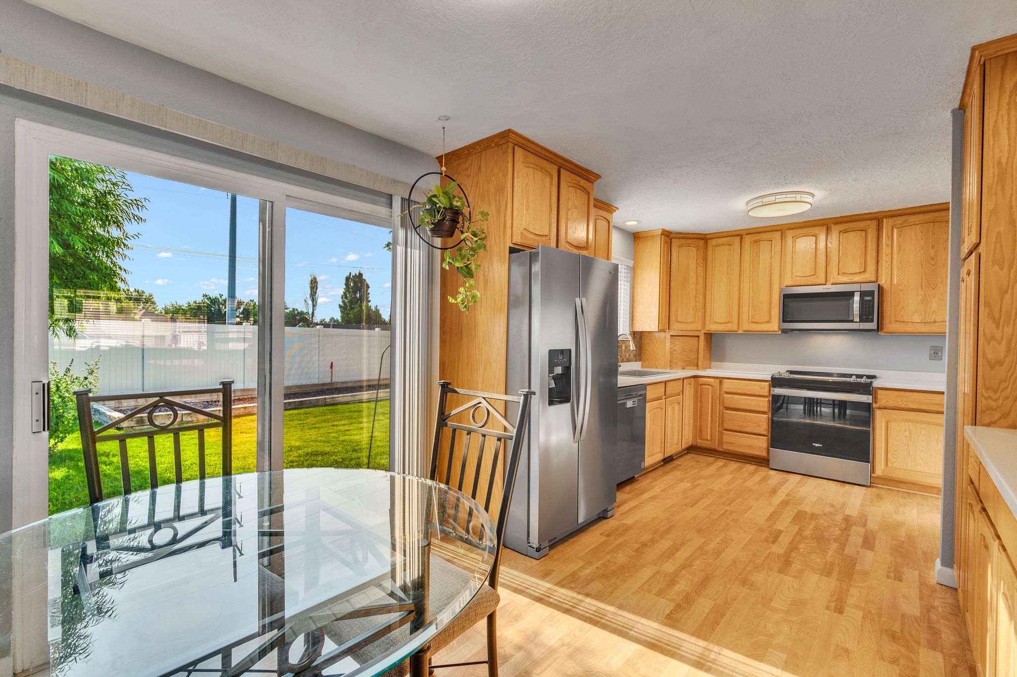 Kitchen with wood-finish flooring, light wood cabinetry, and stainless steel appliances