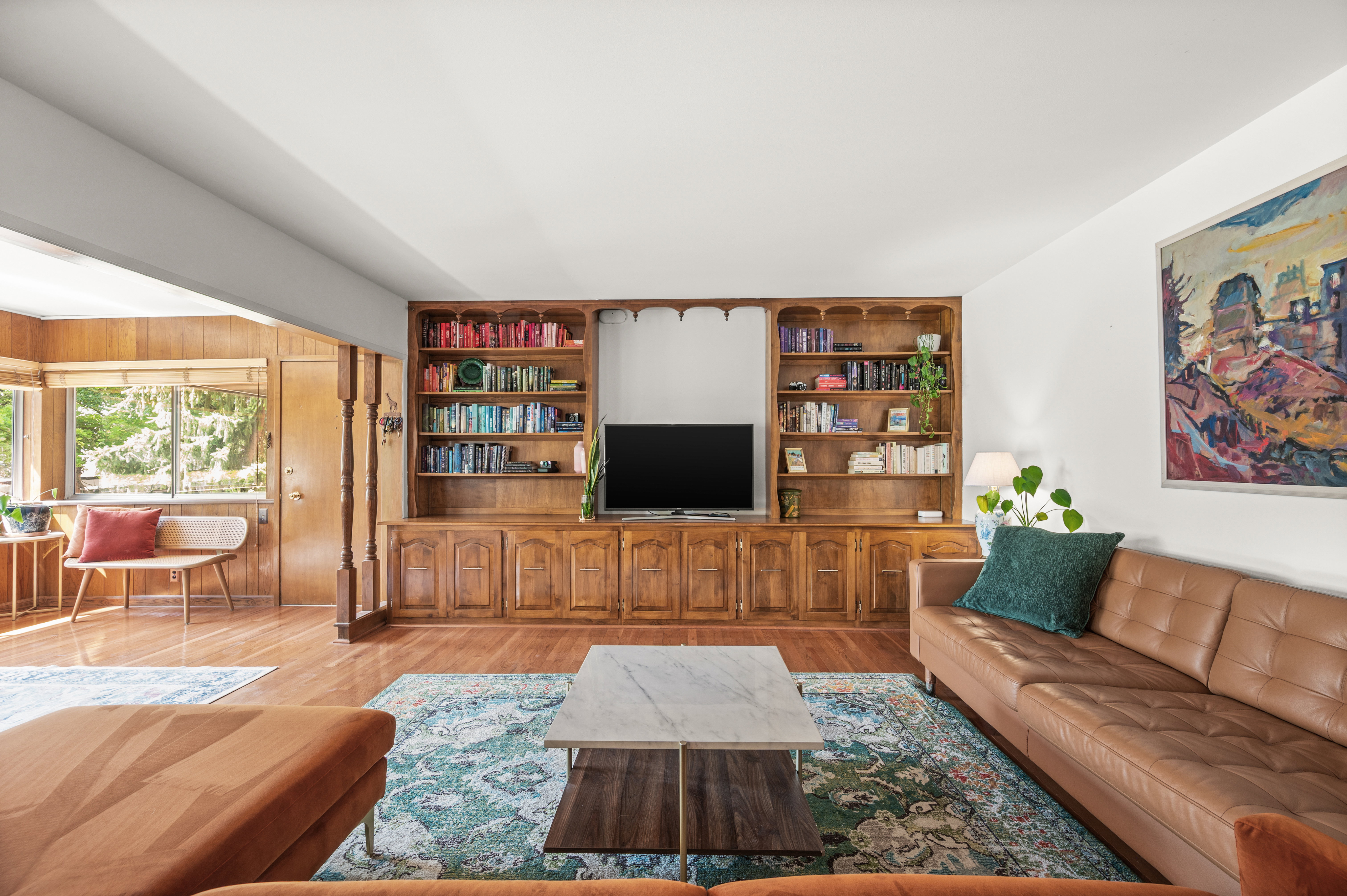 Integrated wood-finish media console with open shelving and lower cabinetry