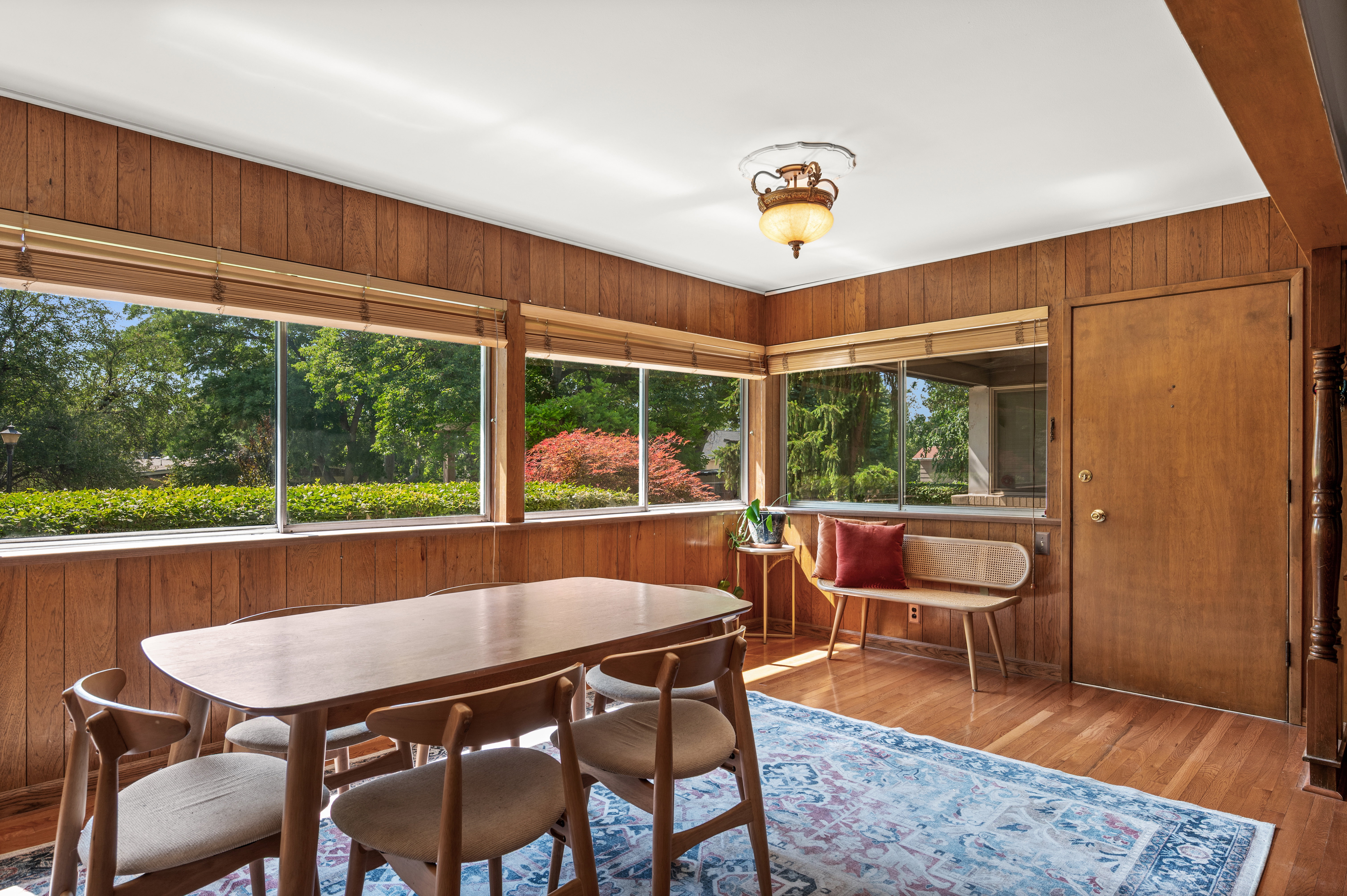 Dining area featuring wood-paneled walls and hardwood flooring