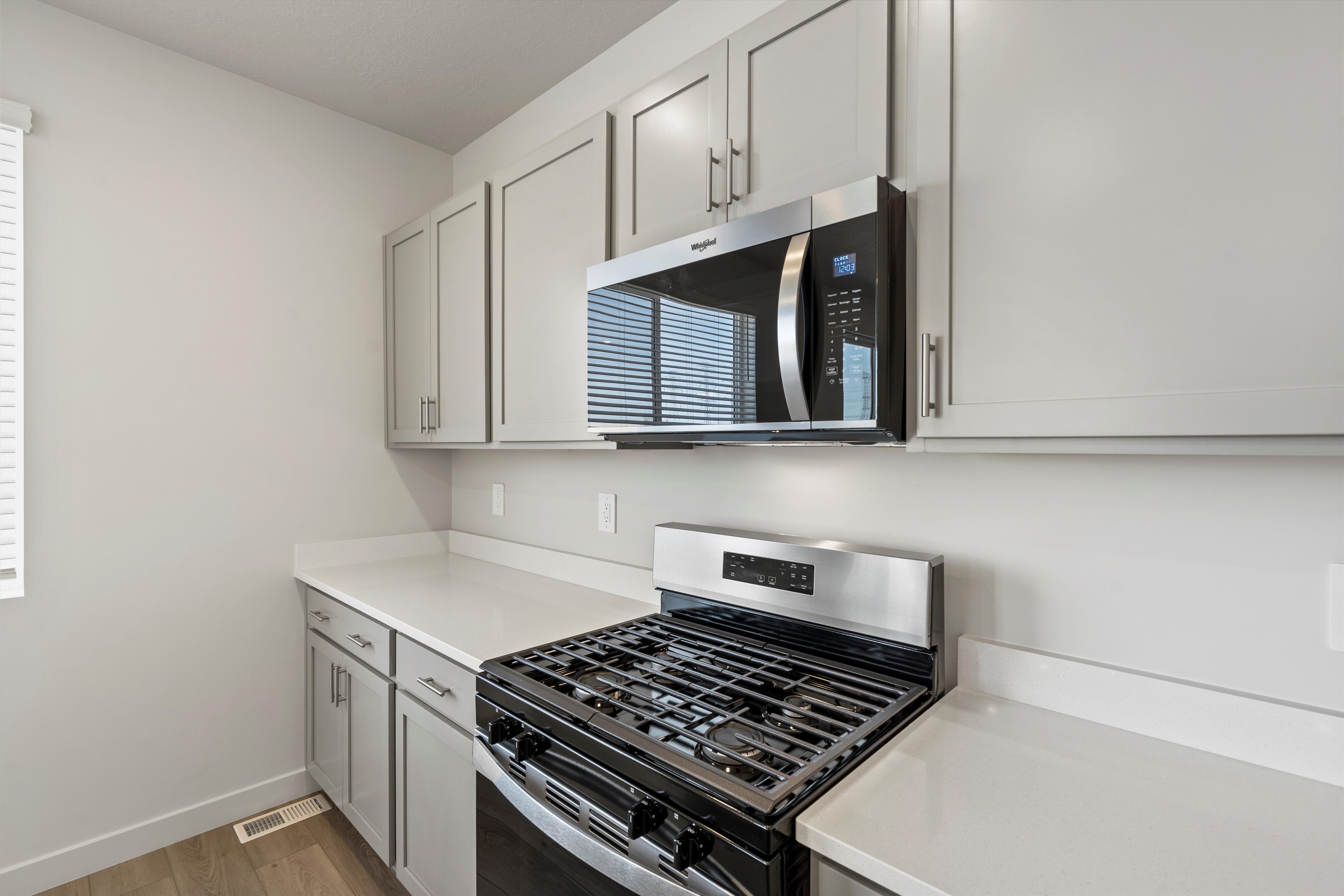 **DISCLAIMER** Interior package may vary. Contemporary kitchen featuring light gray cabinetry, stainless steel appliances, and white countertops