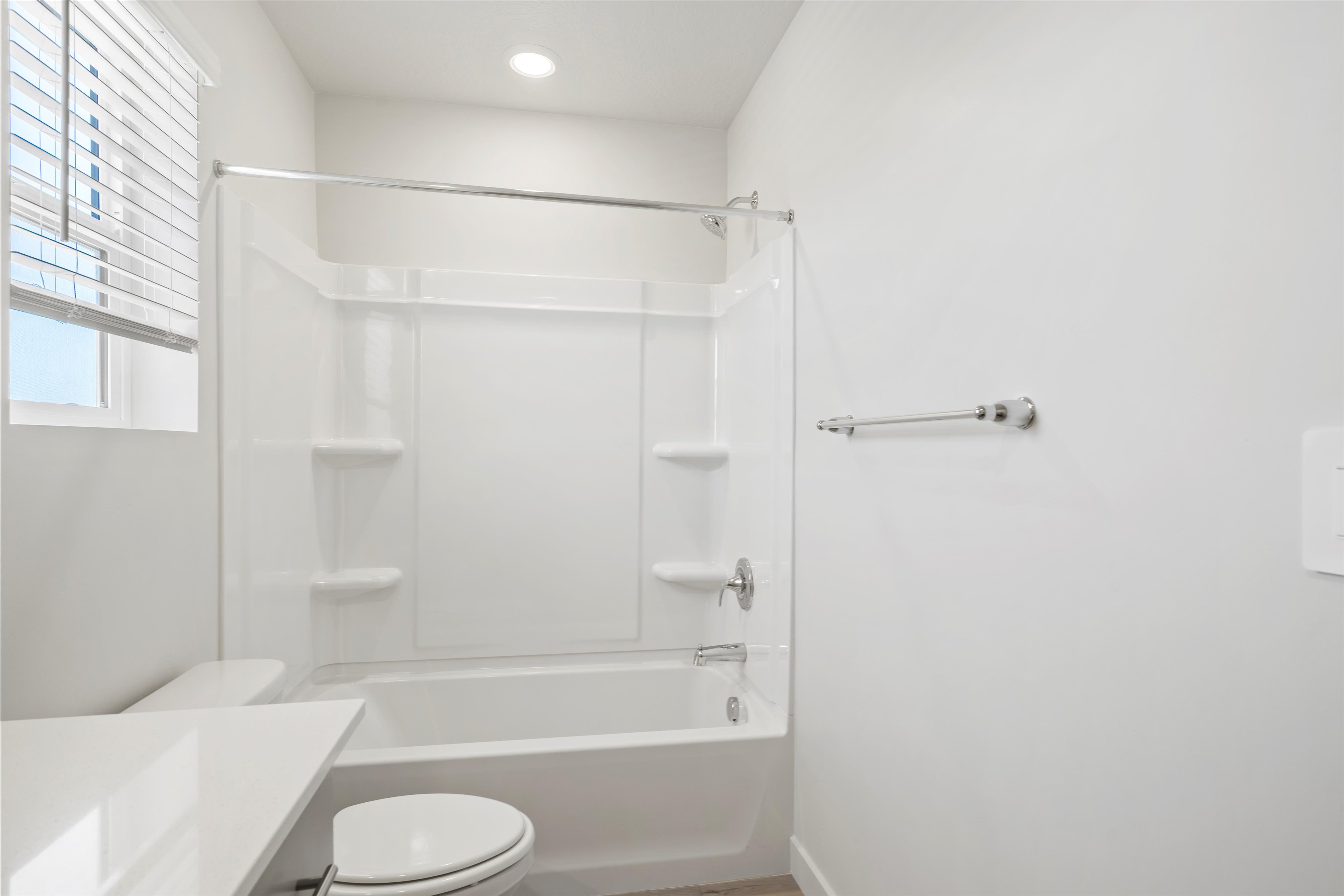 **DISCLAIMER** Interior package may vary. Bathroom featuring a white bathtub and shower surround with integrated shelving