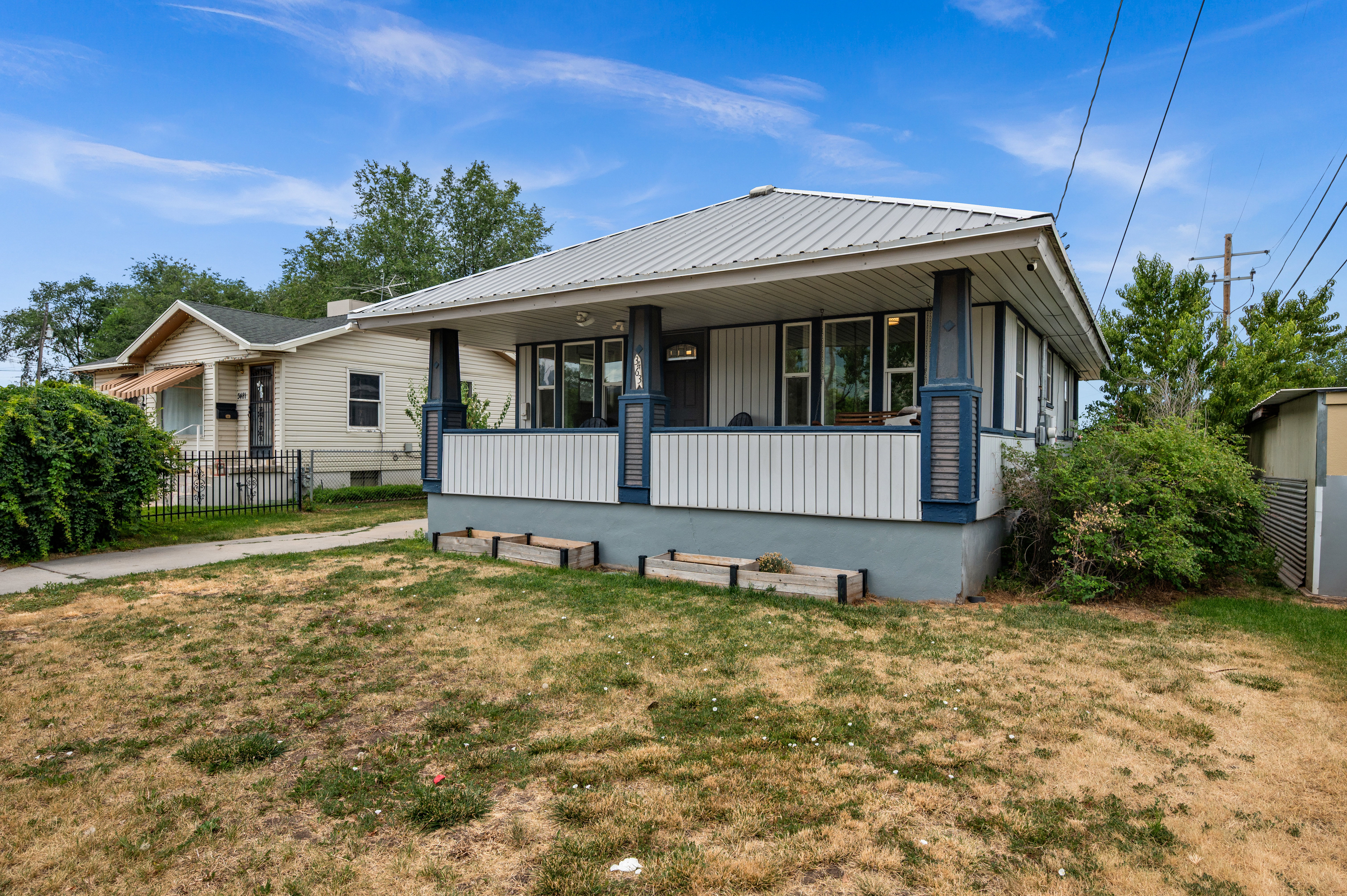 Front exterior featuring a covered porch with decorative columns, a metal roof, and horizontal siding