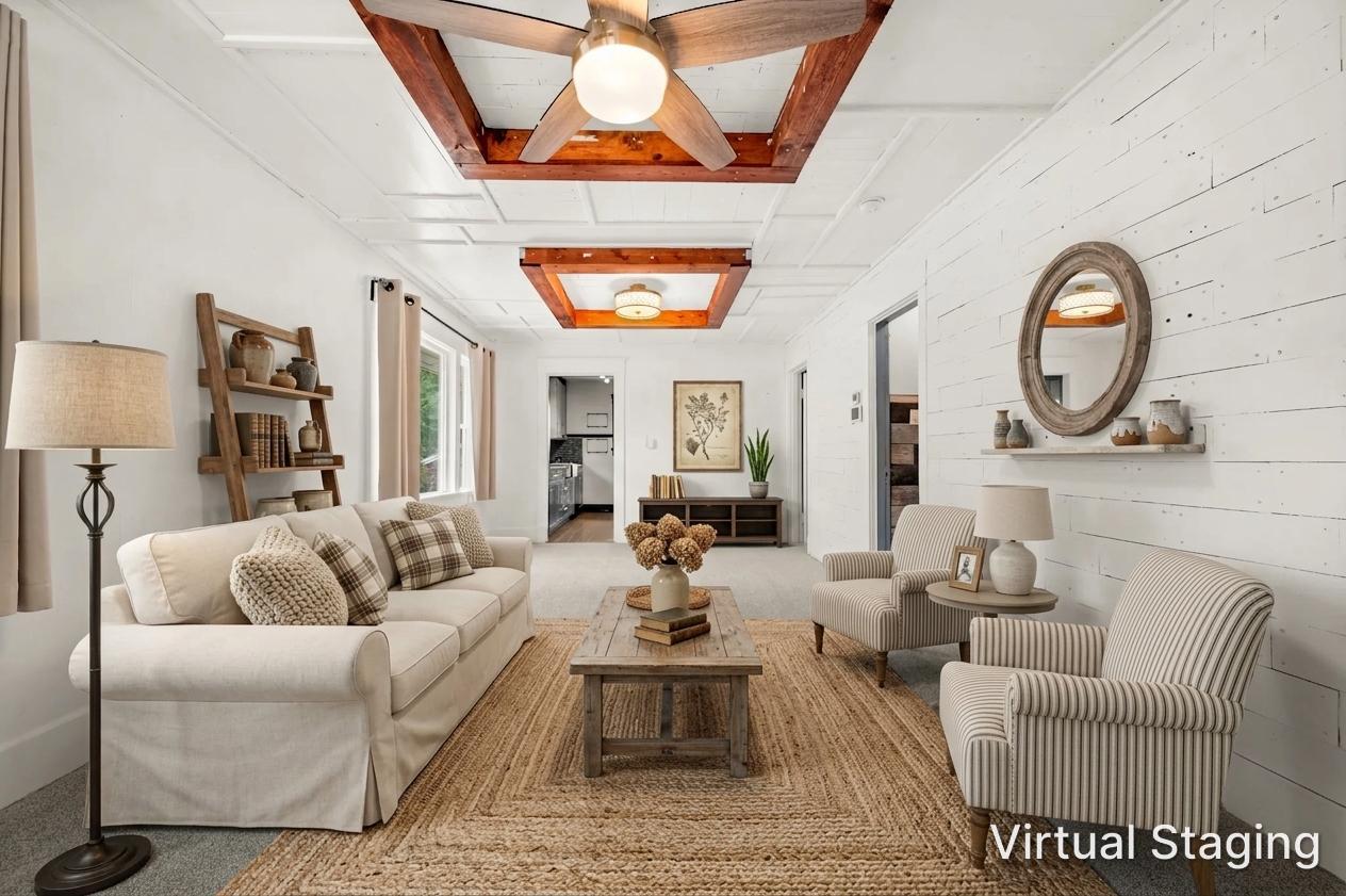 Spacious living area featuring exposed wood beam accents, white shiplap wall detailing, and recessed panel ceiling