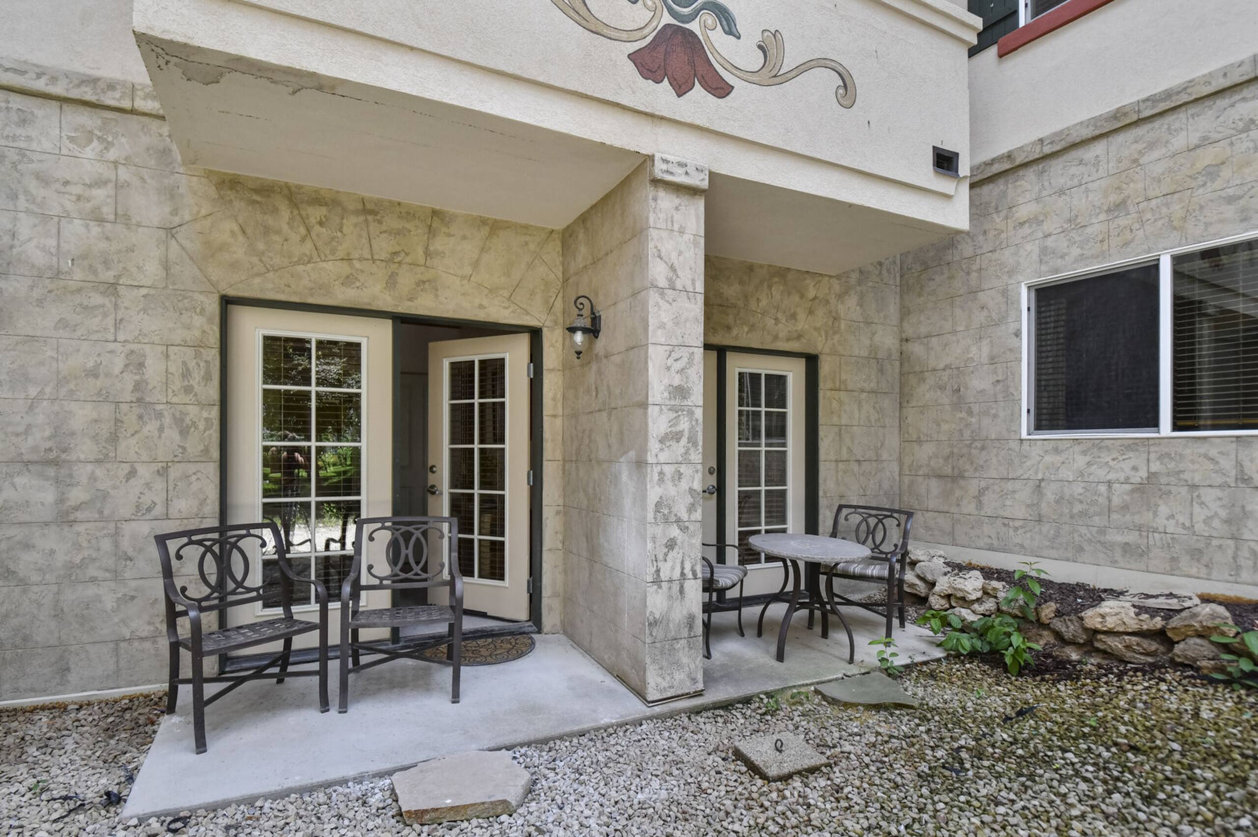 Private patio area featuring a concrete surface and gravel landscaping