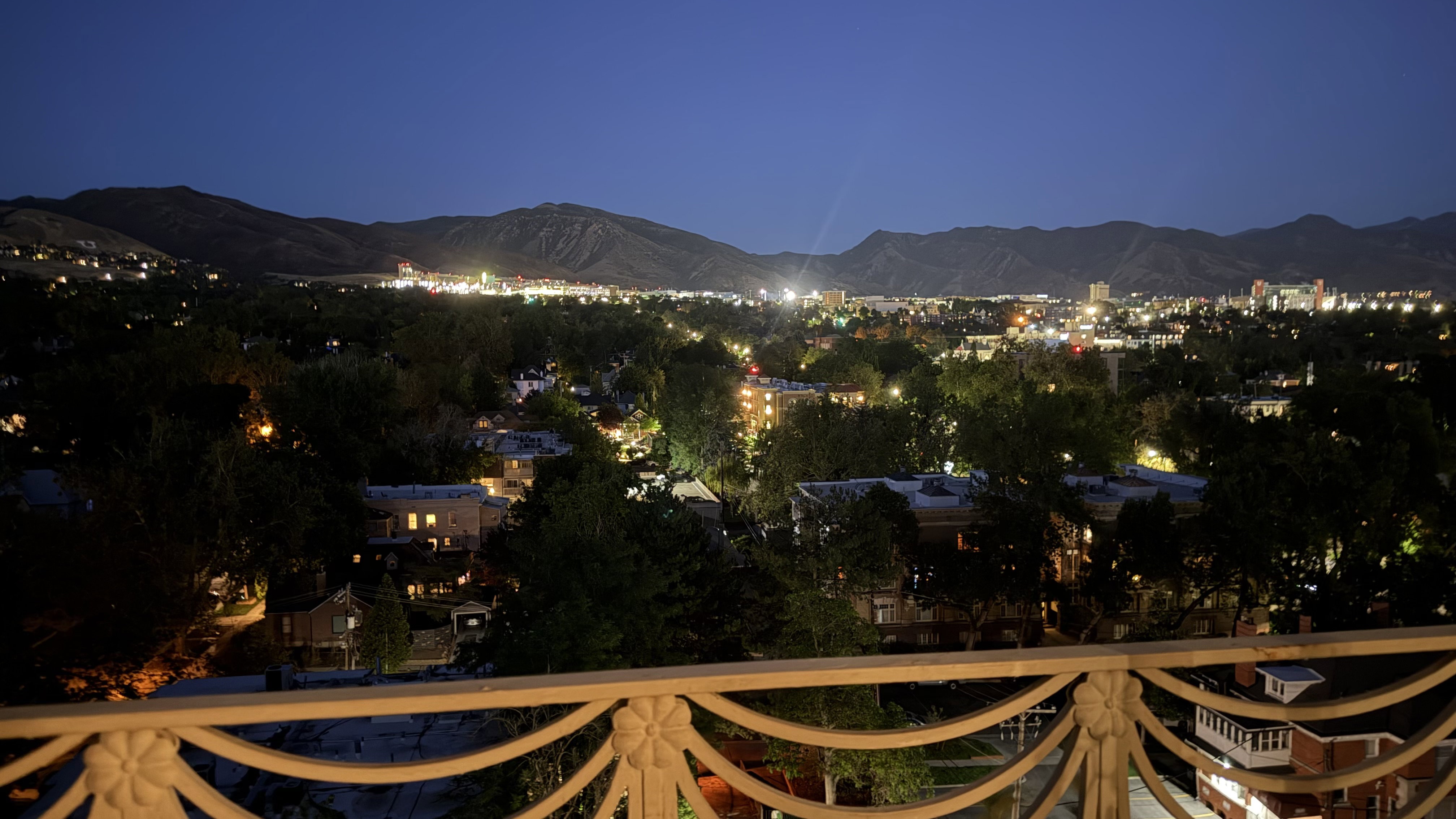 Cityscape with illuminated buildings and distant mountains