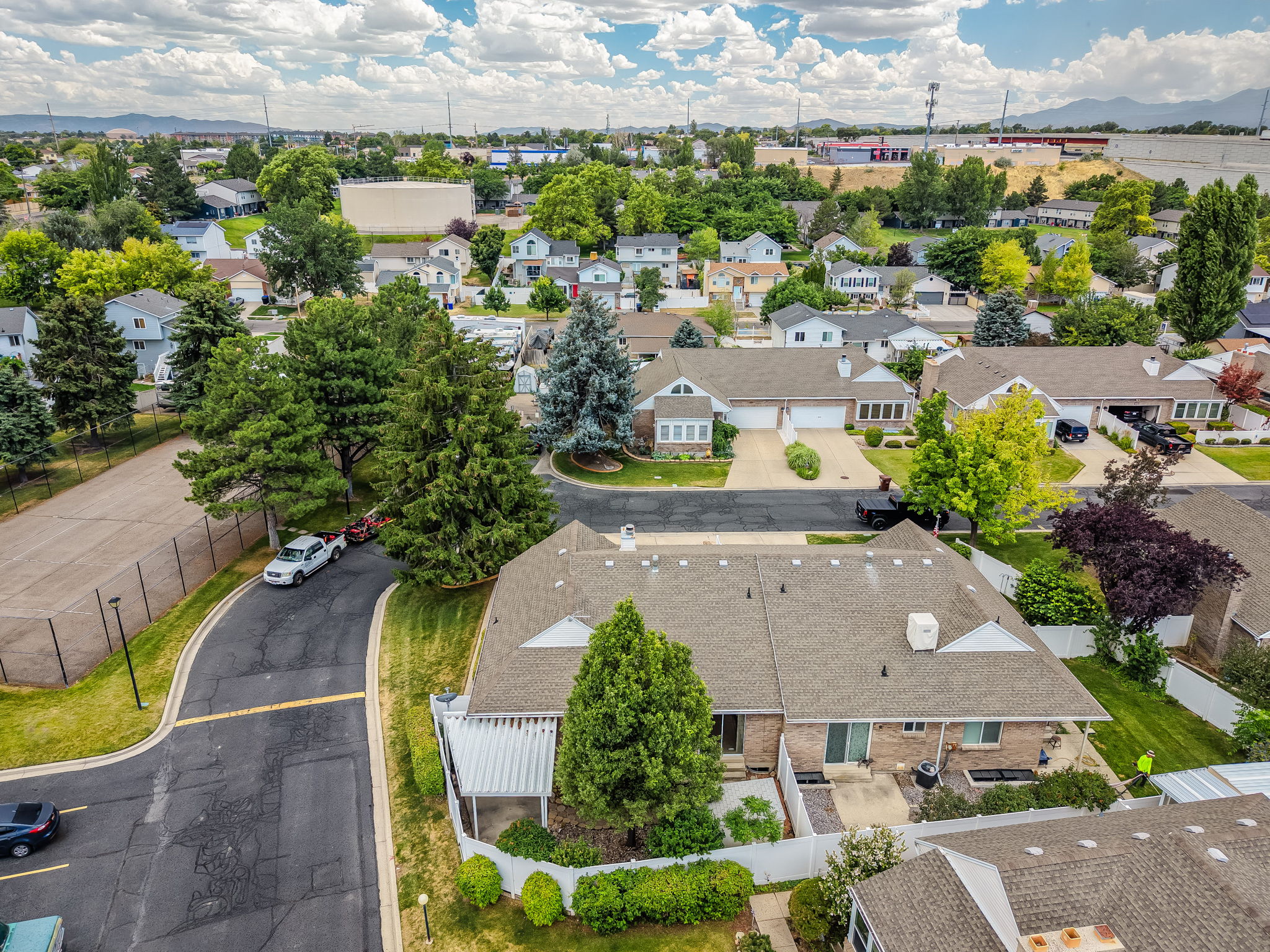 Neighborhood setting with mature trees and a paved street