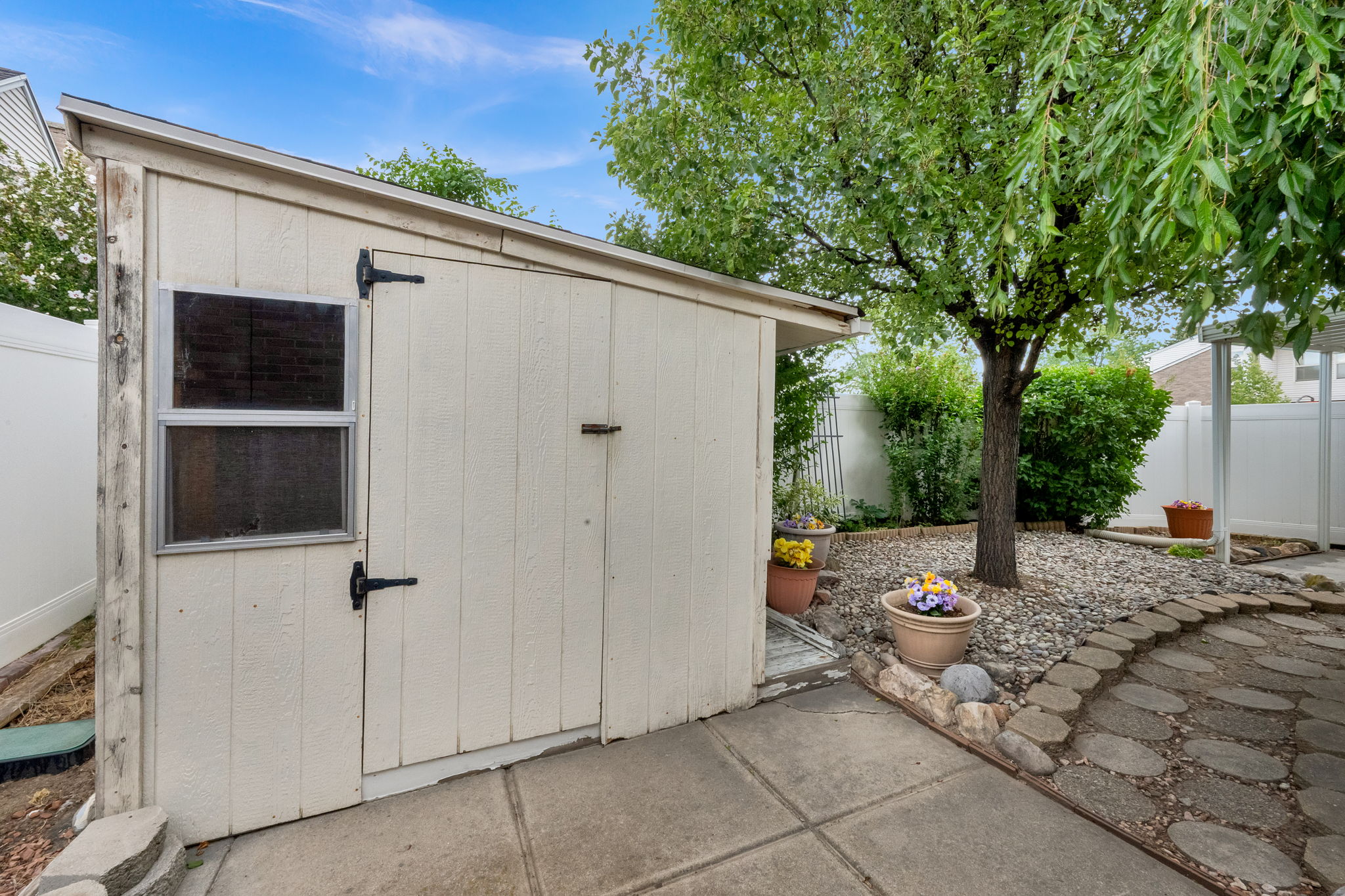 Exterior storage shed with a lean-to roof, a side window, and a single entry door
