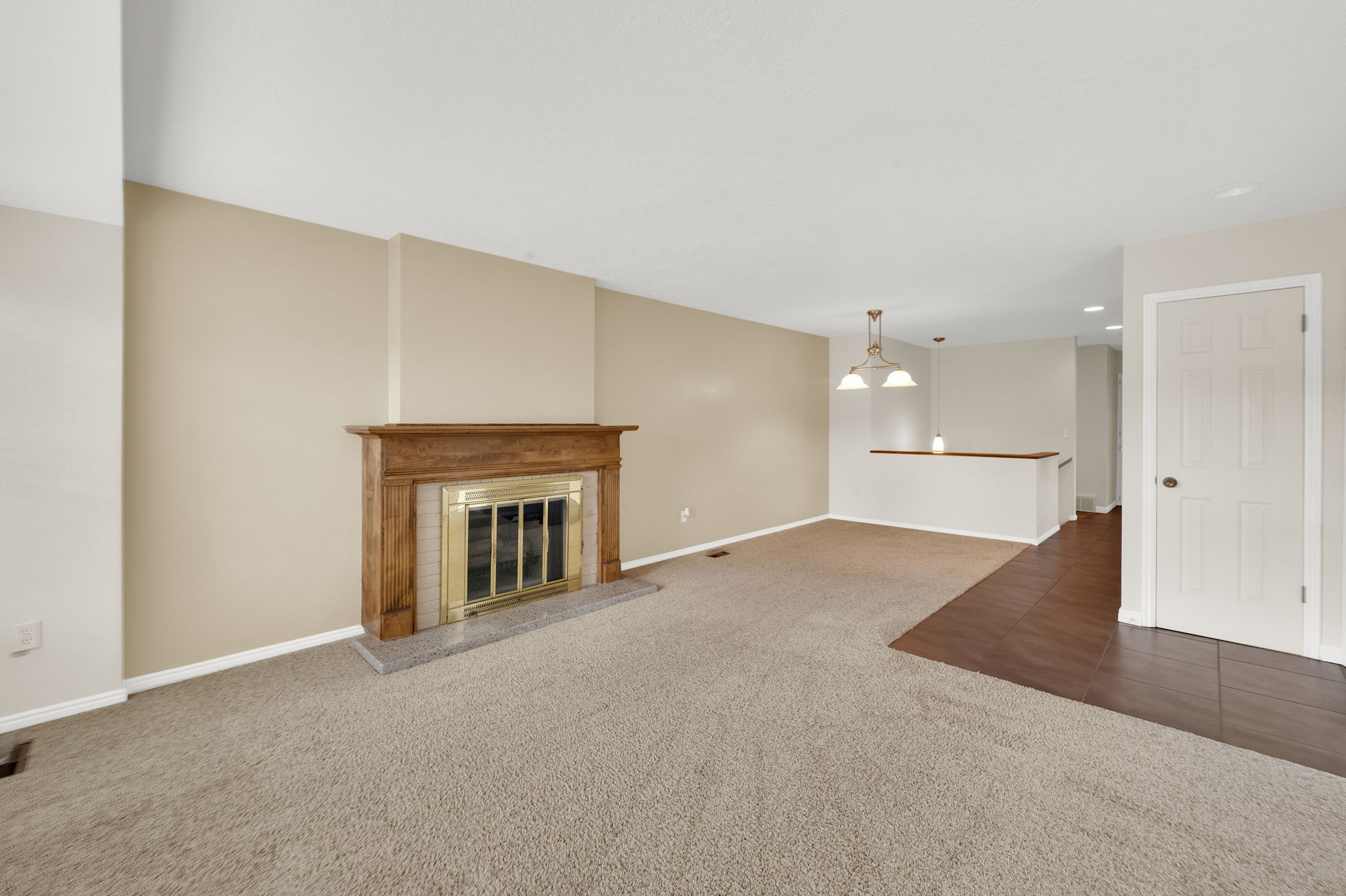 Living area featuring a fireplace with a wood mantle and a light-toned stone hearth
