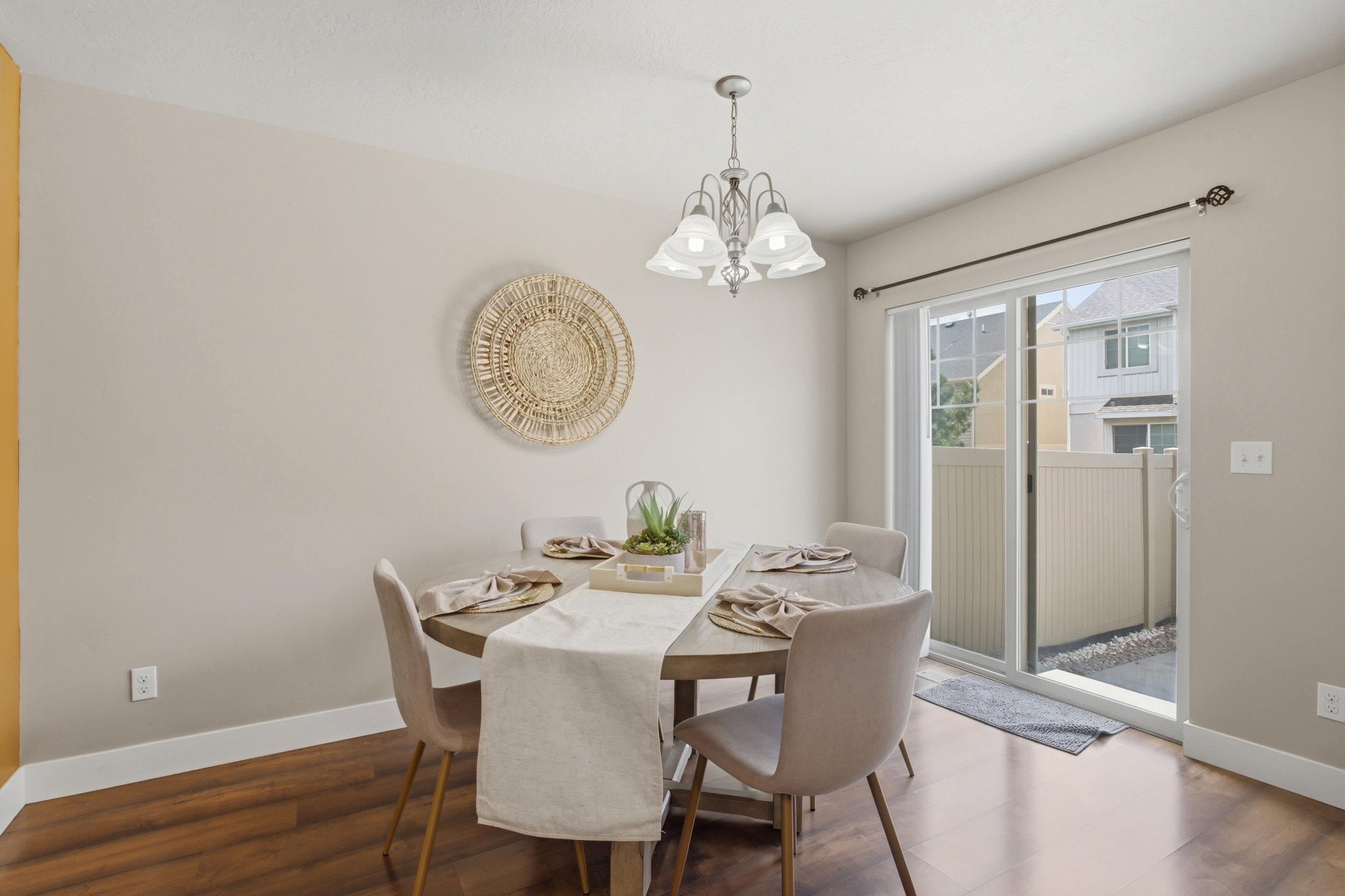 Dining area featuring wood-finish flooring, a contemporary chandelier, and a sliding glass door opening to a private outdoor space