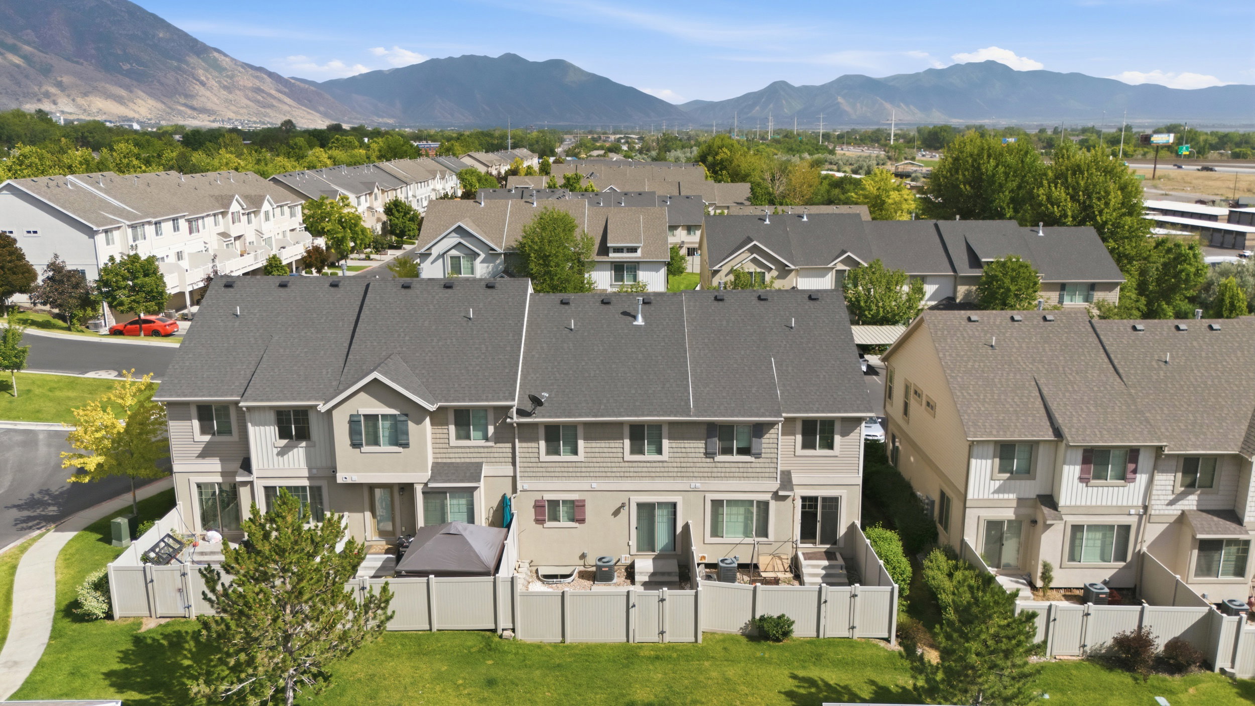 Townhome community featuring multi-level residences with private patios and mountain backdrops