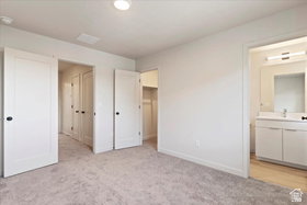 Carpeted room featuring white walls, a recessed ceiling light, and white interior doors with dark hardware
