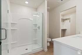 Walk-in shower with clear glass enclosure and built-in shelving