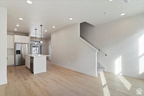 Open-concept living space featuring wood-finish flooring, recessed lighting, and a modern kitchen