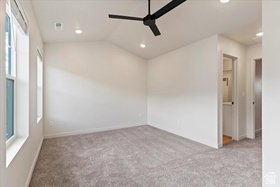 Spacious room featuring vaulted ceilings, recessed lighting, a contemporary black ceiling fan, two windows, and gray carpeting
