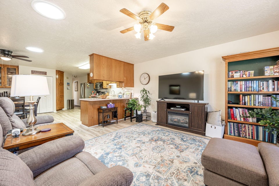 Open-concept living area featuring light-toned walls, wood-finish flooring, and built-in shelving