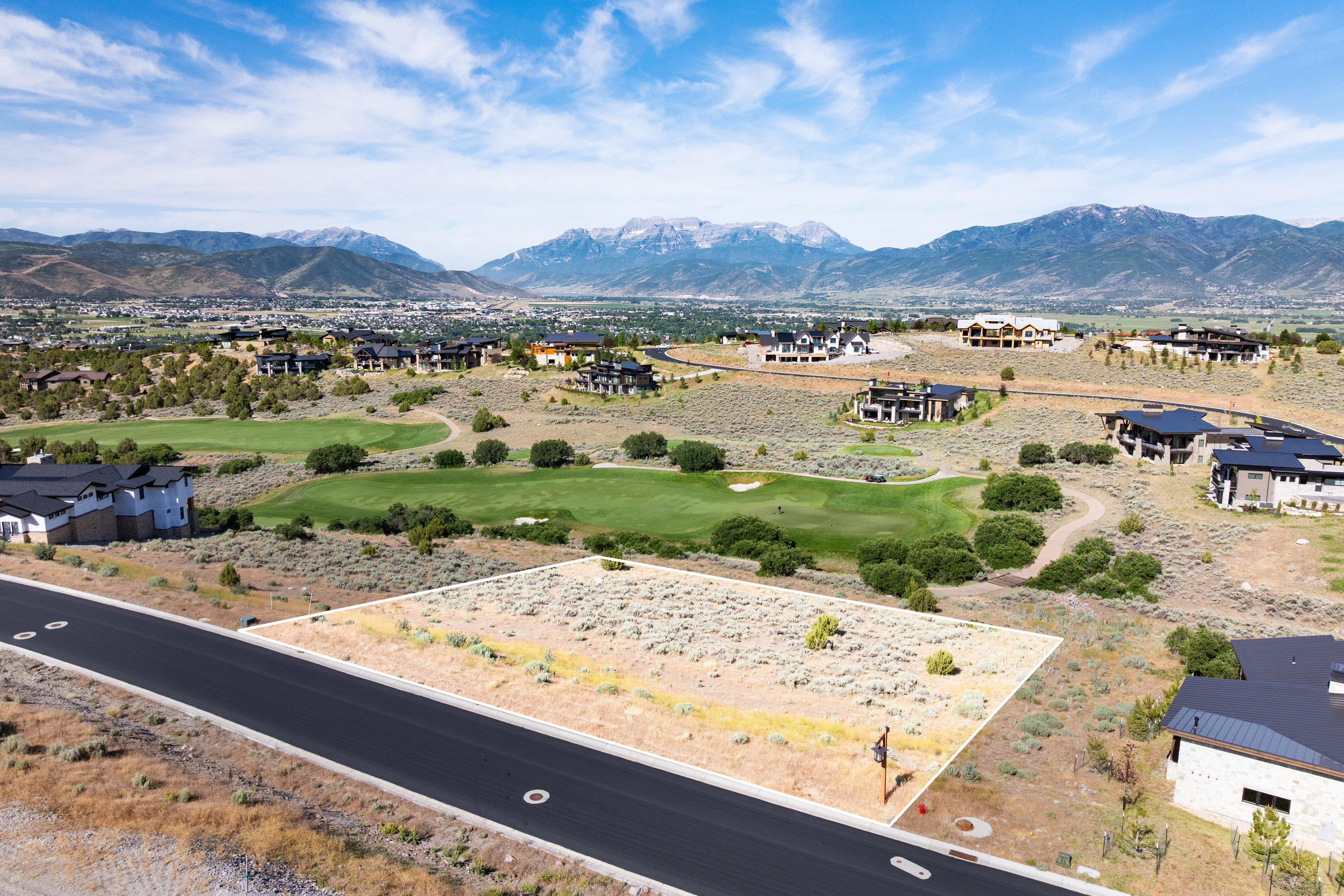 Expansive land lot featuring a level building area, paved road frontage, and established utility access