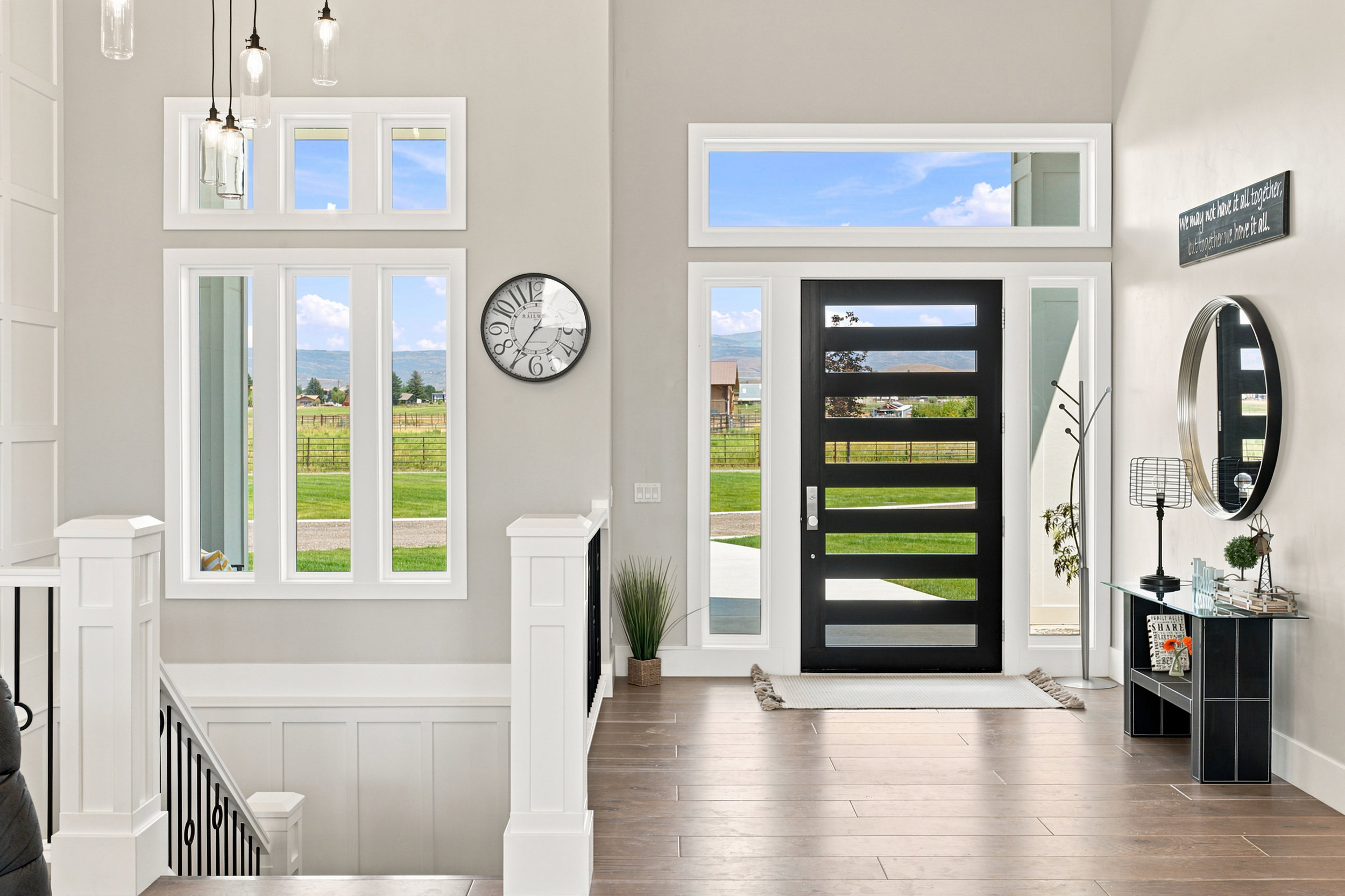 Contemporary entry door with five horizontal lites, flanked by sidelights and a transom window