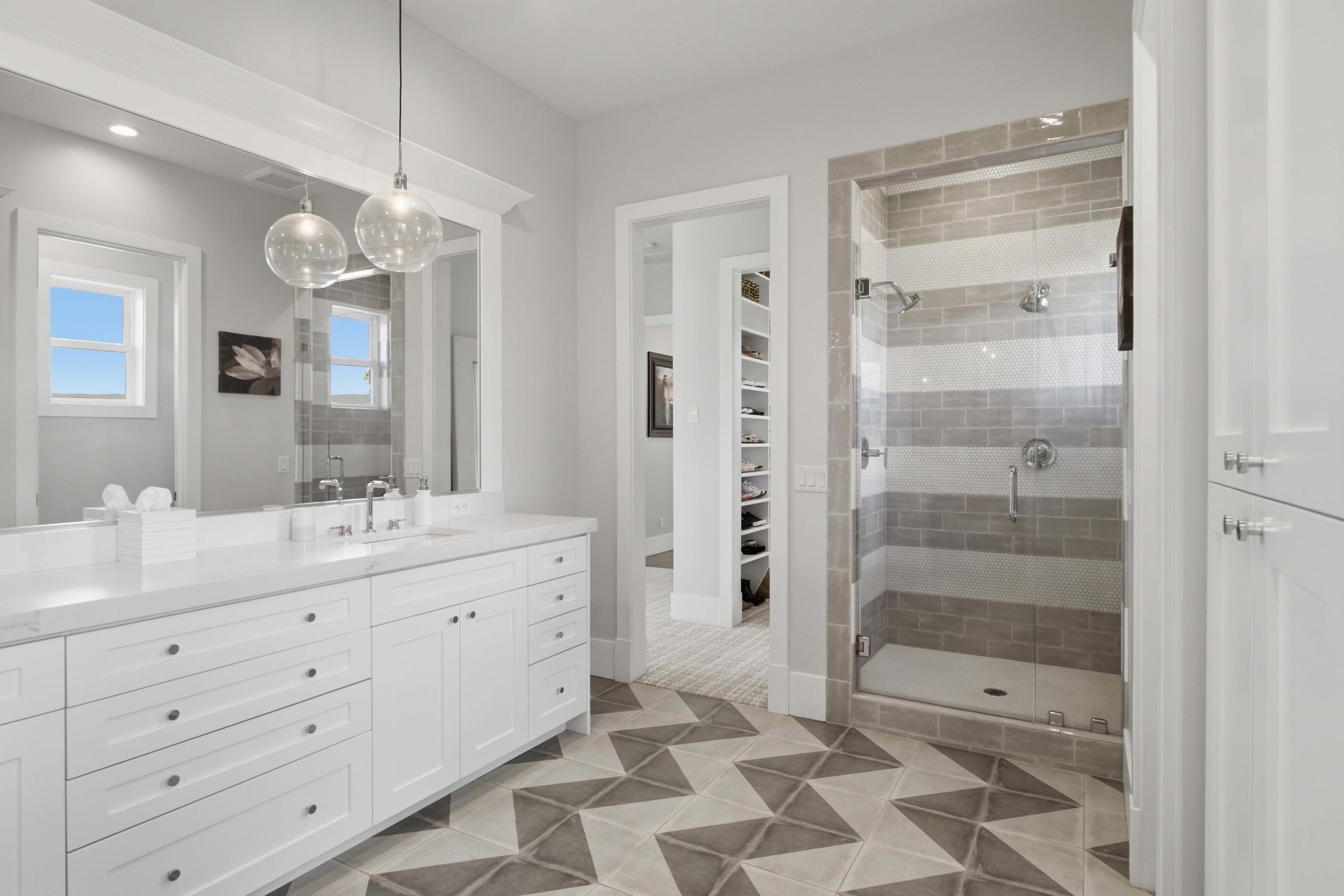 Double vanity with white cabinetry and a light-colored countertop