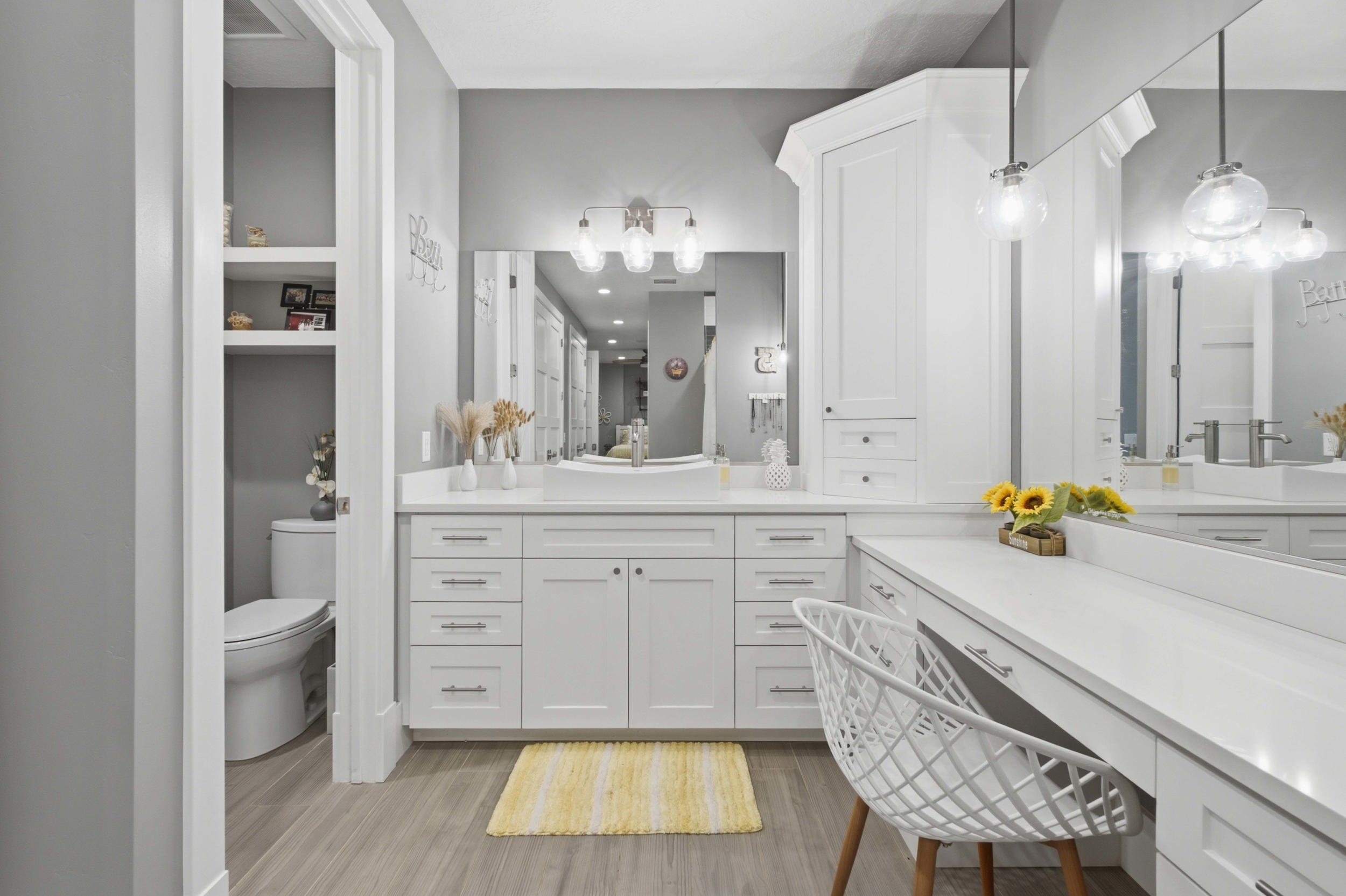 Spacious bathroom featuring an extended vanity with dual sinks, quartz countertops, and abundant white cabinetry
