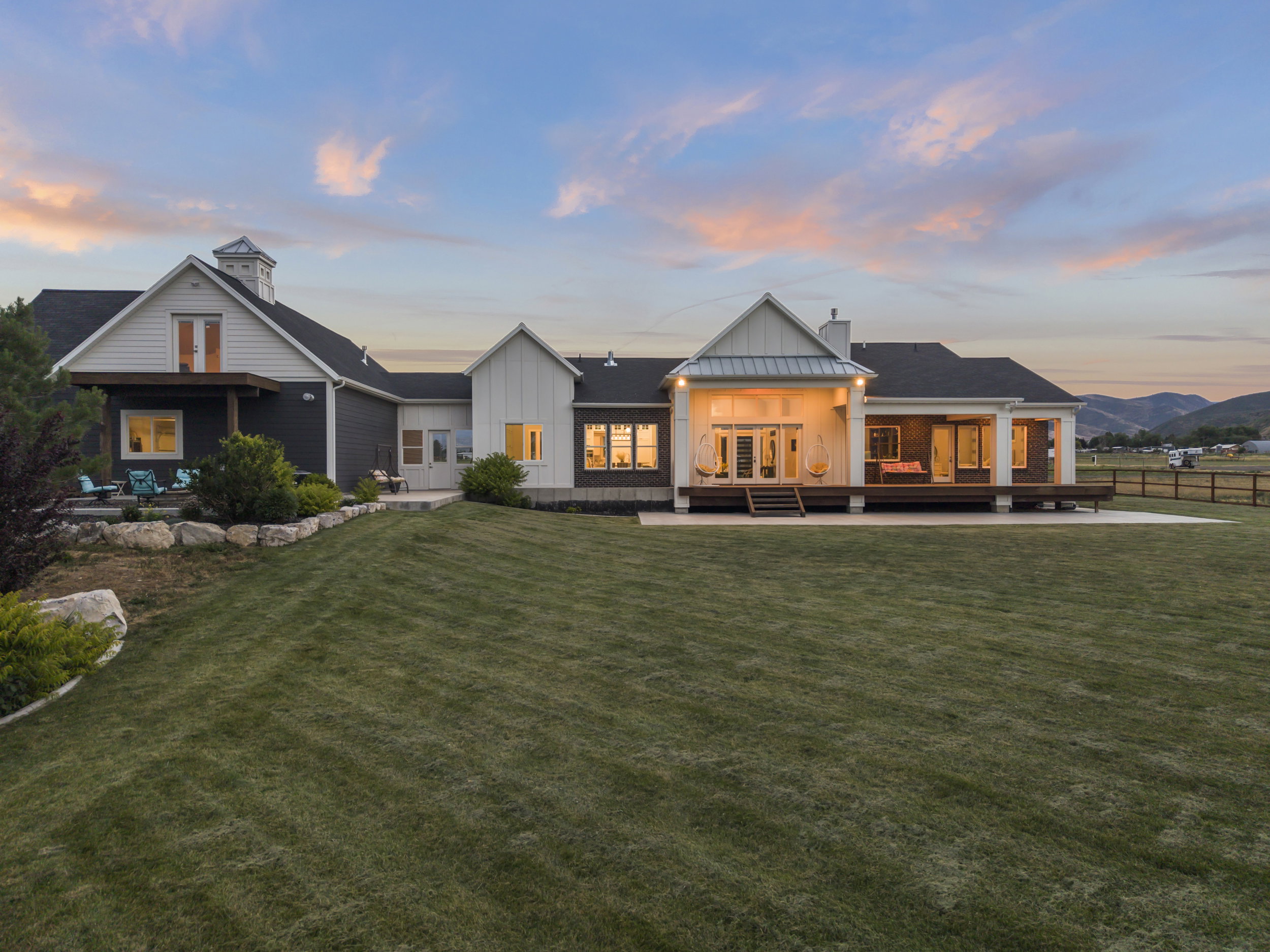 Spacious rear elevation featuring a multi-level deck, expansive patio, and large lawn area