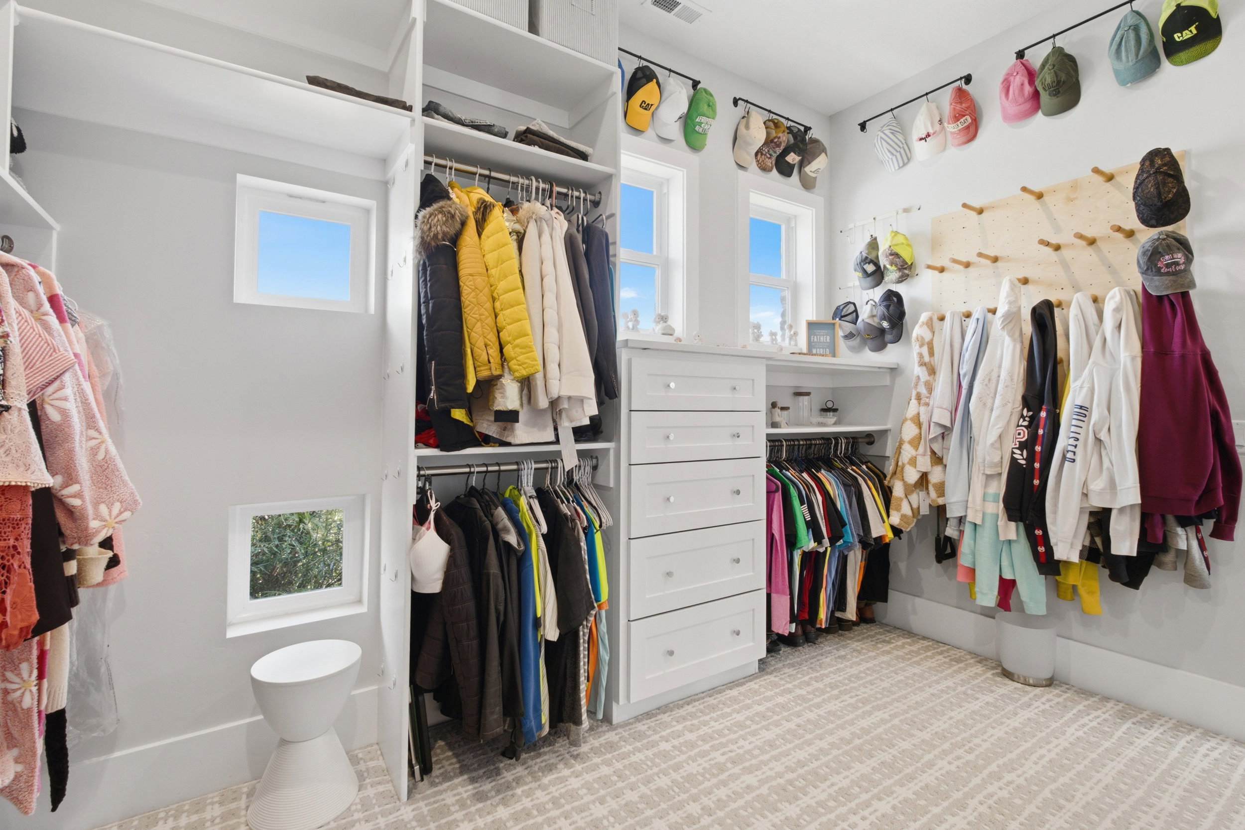 Custom-designed closet system featuring floor-to-ceiling storage, multiple built-in drawers, and ample hanging space