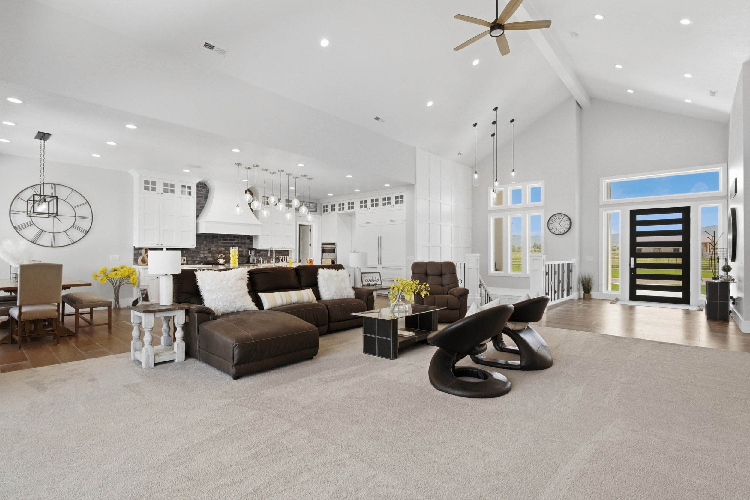 Vaulted ceiling great room featuring a modern front door, wood-finish flooring, recessed lighting, and a contemporary ceiling fan