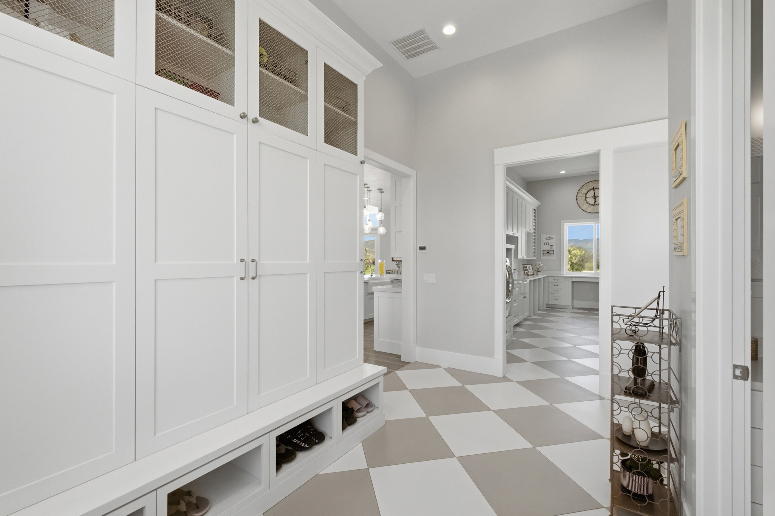 Built-in white cabinetry with wire mesh upper doors and lower cubbies provides extensive storage