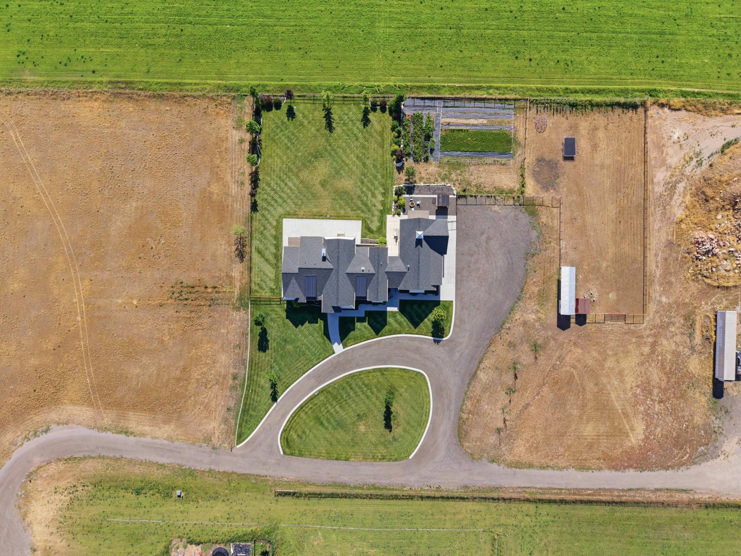 Aerial overview of a substantial property featuring a main residence with a multi-gabled roofline