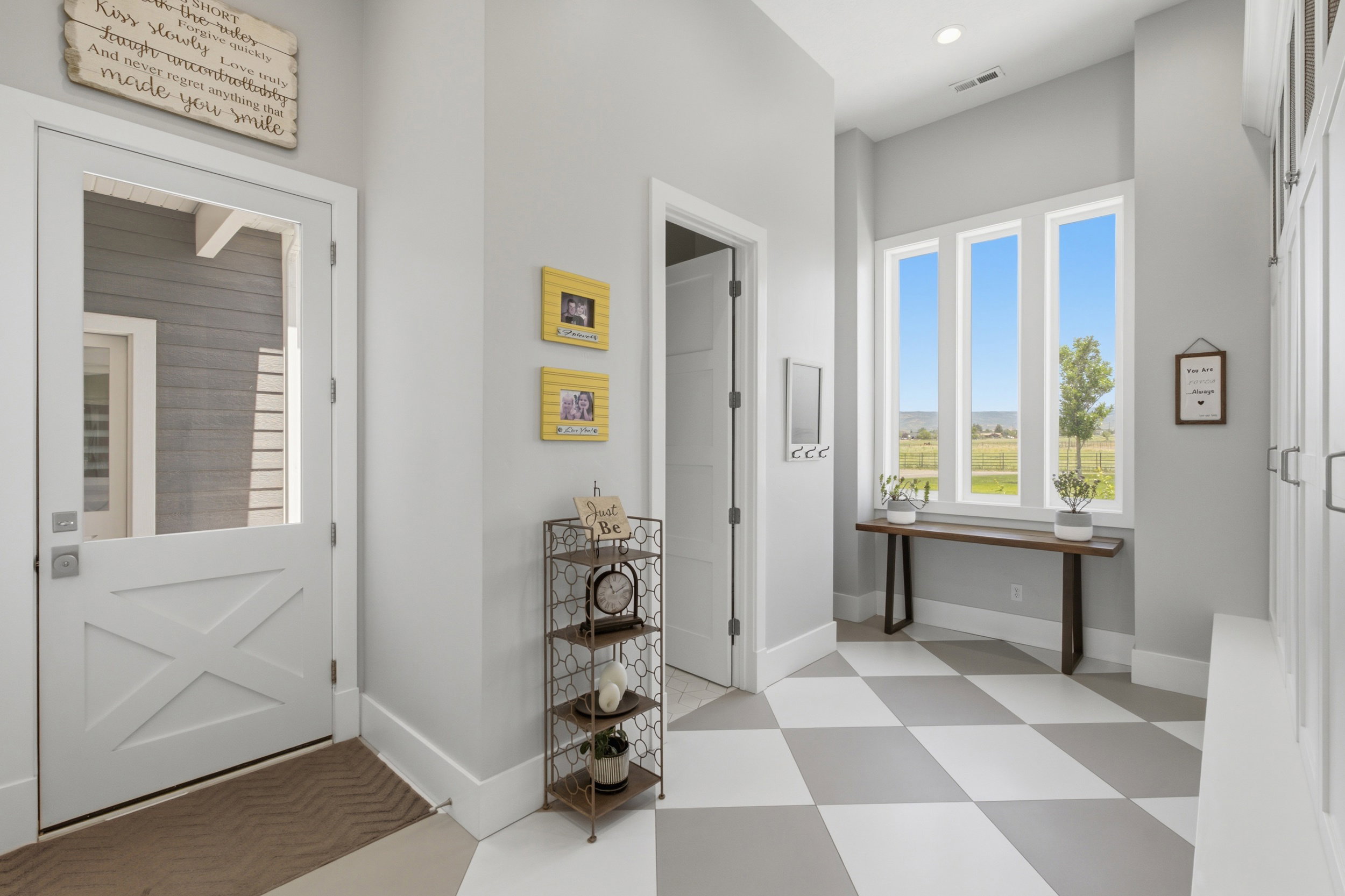 Entryway featuring a white Dutch door with clear glass panel, large picture windows, recessed lighting, and checkerboard floor tiles