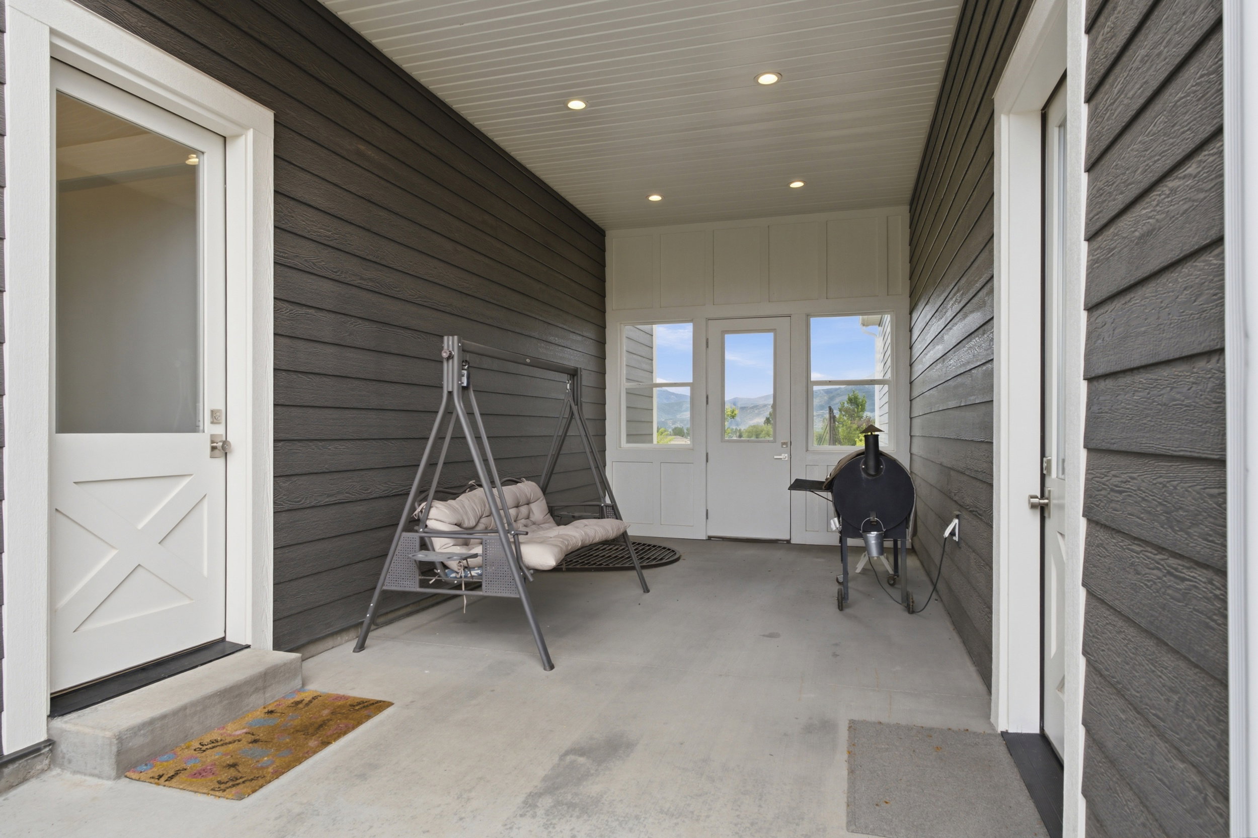 Covered patio featuring plank siding, recessed lighting, and concrete flooring