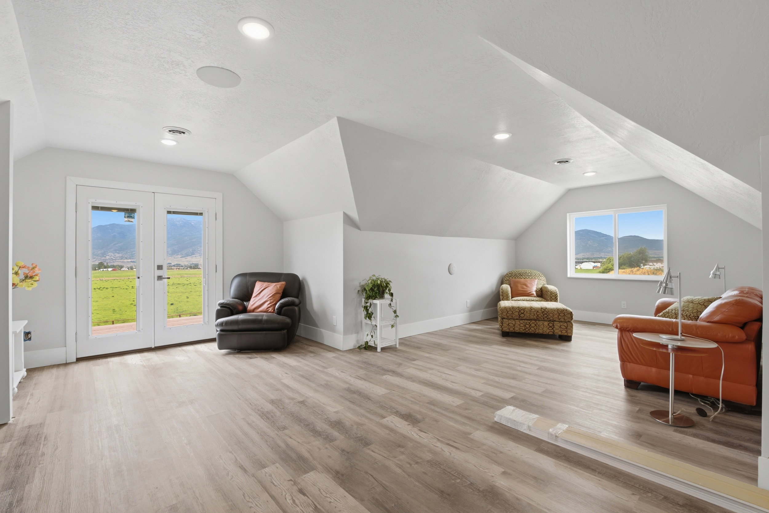 Spacious loft area featuring wood-finish flooring, recessed lighting, and white baseboards