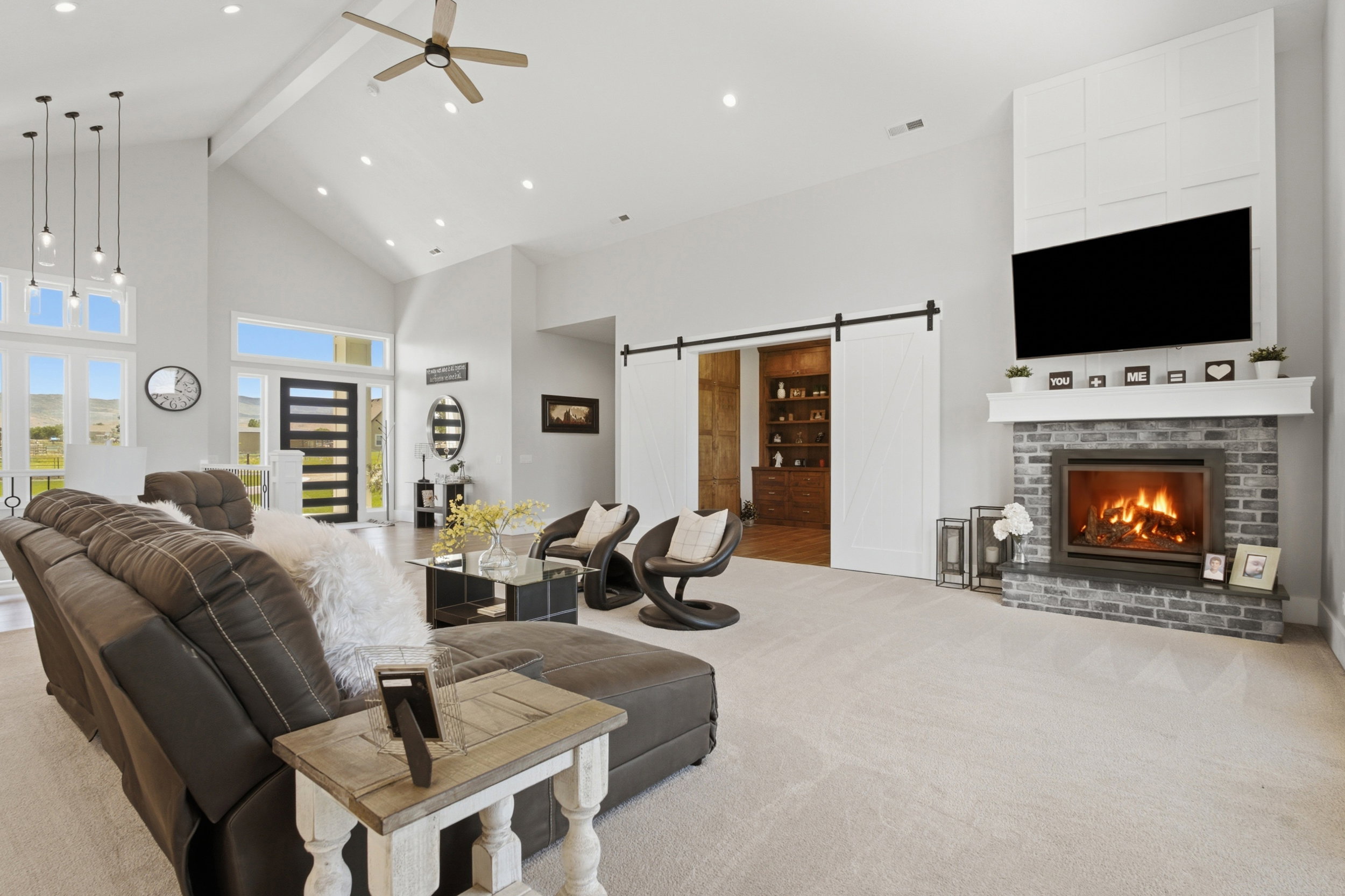 Spacious living area featuring vaulted ceilings, recessed lighting, and a modern ceiling fan