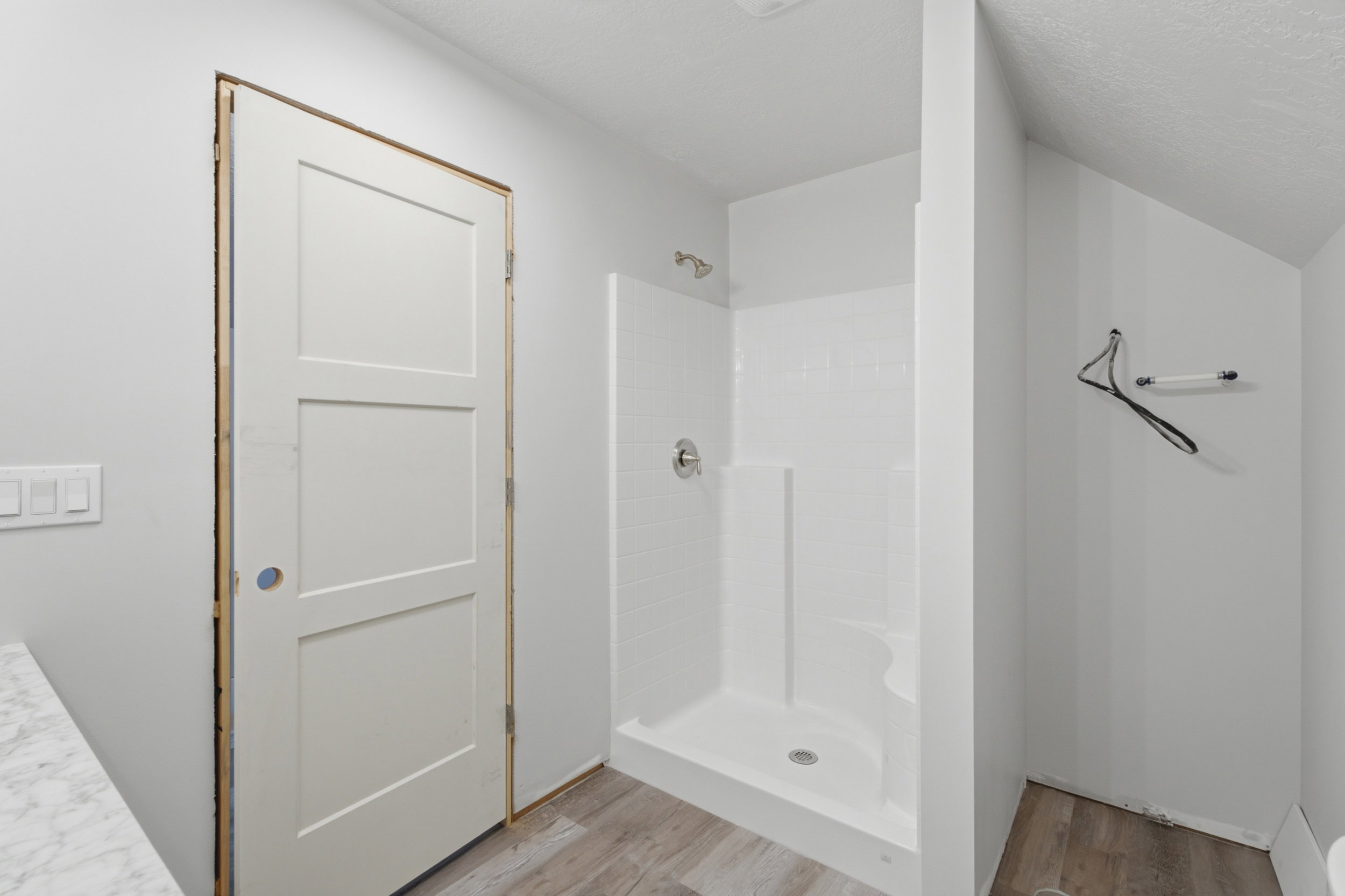 Bathroom featuring a standing shower with a built-in seat, a chrome showerhead, and a three-panel interior door