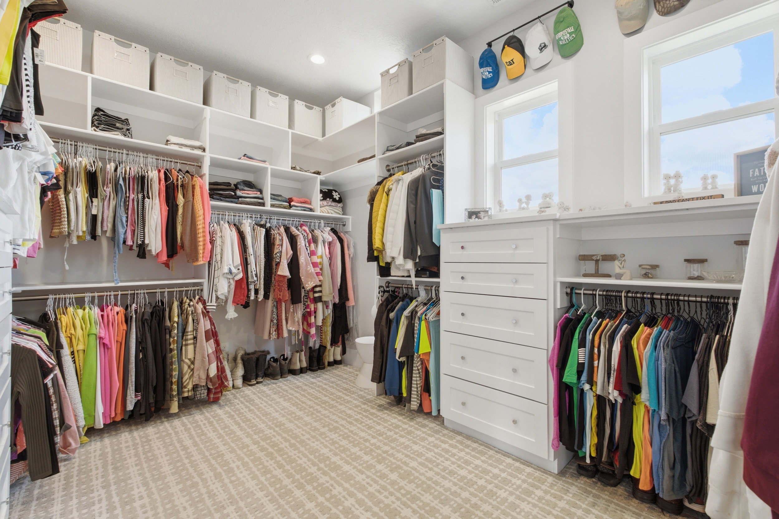 Custom-built closet system featuring integrated drawers, shelving, and hanging rods