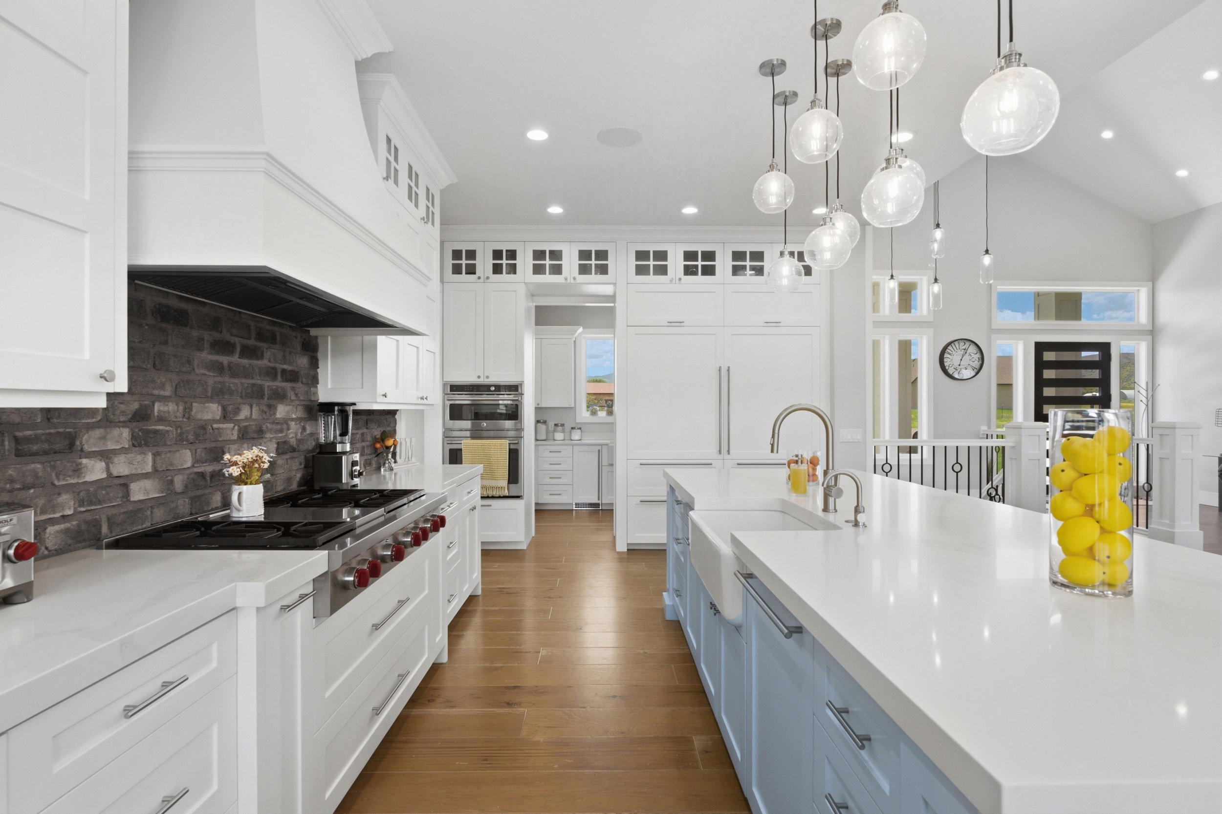Gourmet kitchen featuring a substantial central island with a farmhouse sink, stainless steel faucet, and pendant lighting
