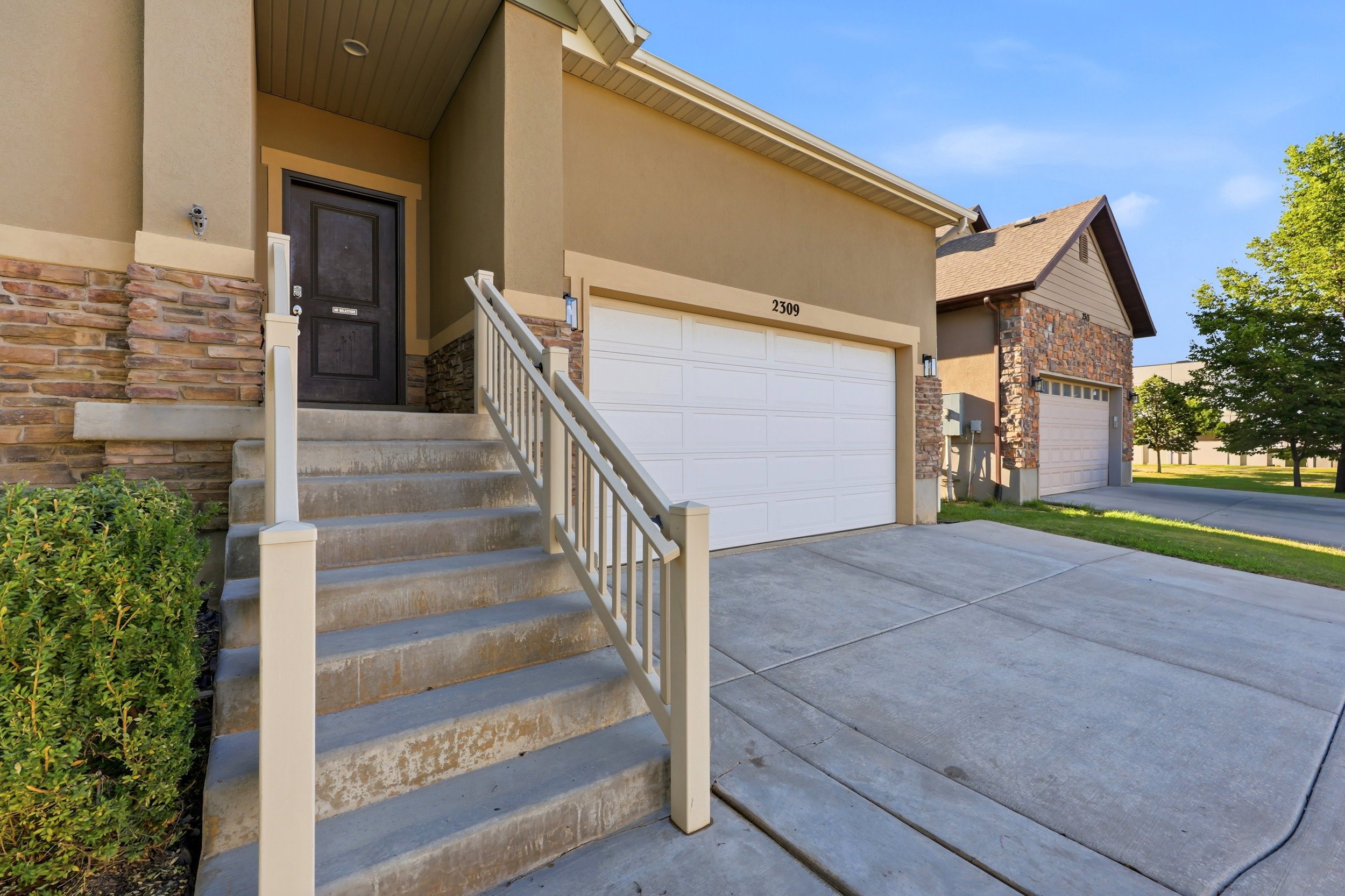 Exterior featuring a two-car garage, stone veneer accents, and a covered entryway