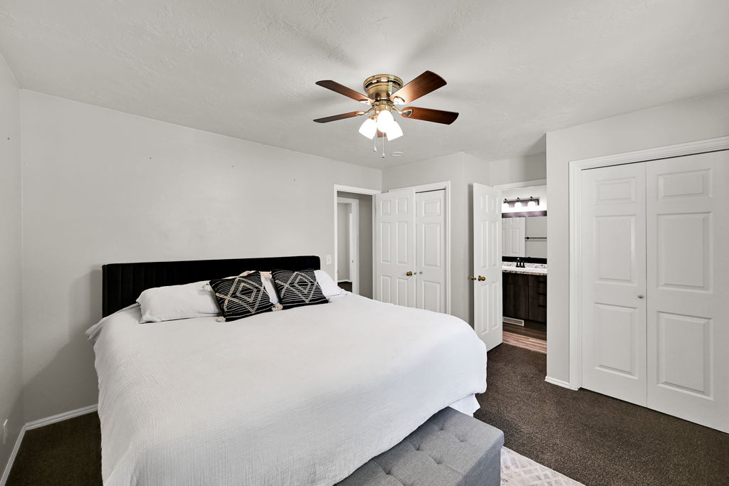 Bedroom featuring plush carpeting and a ceiling fan with integrated lighting