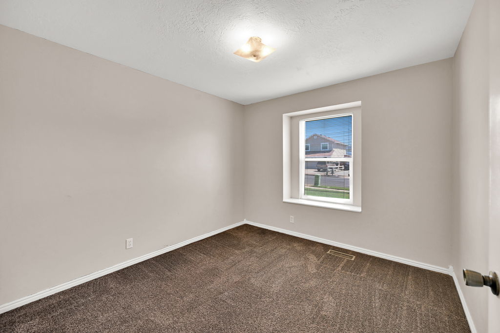 Neutral-toned wall paint with a single window featuring a white frame and blinds