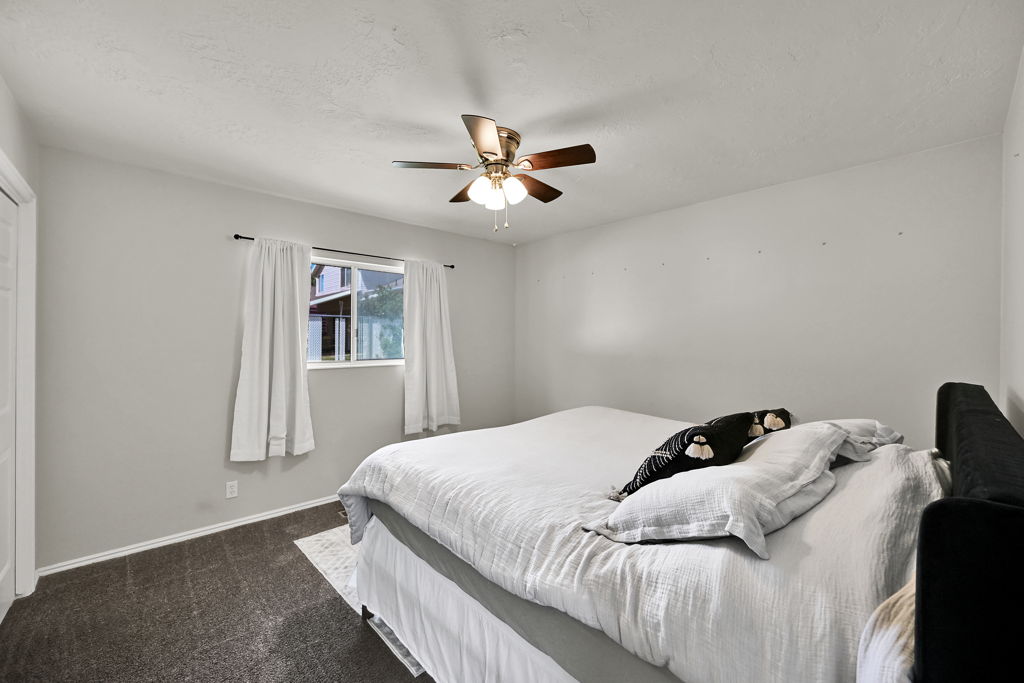 Bright bedroom with neutral wall tones and dark carpeting