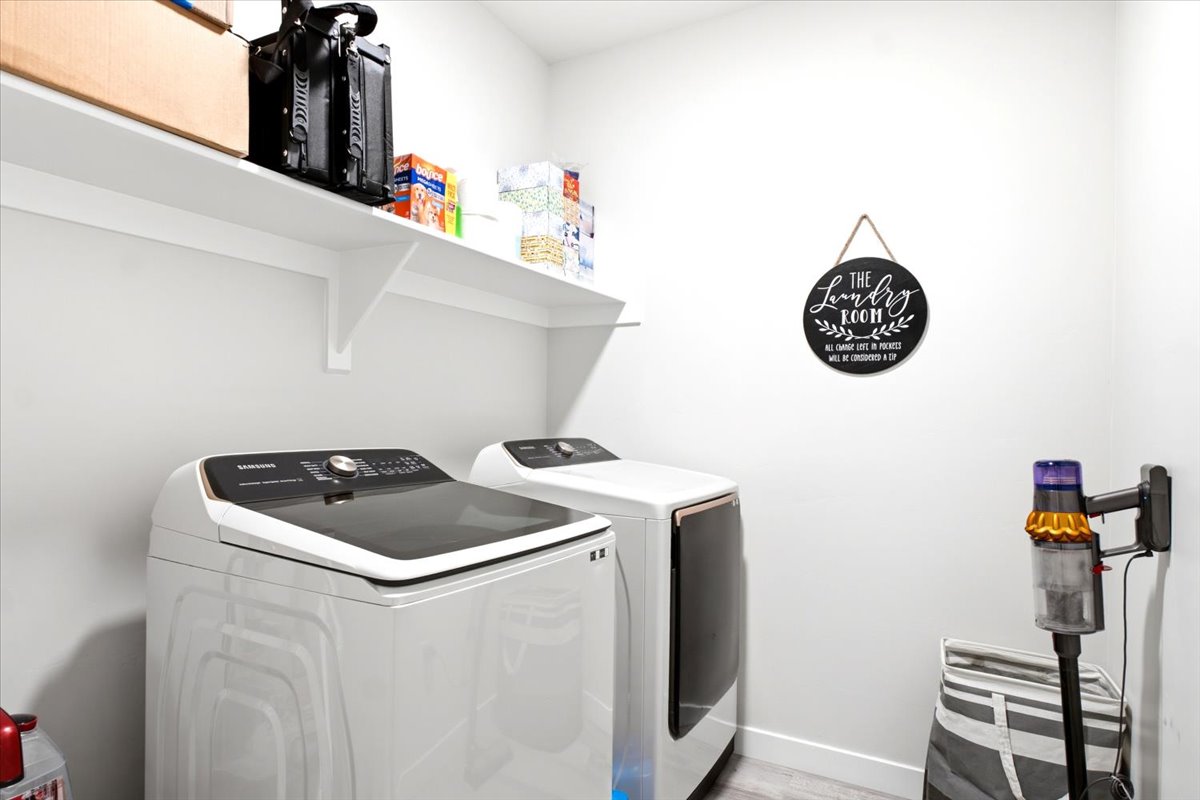 Dedicated laundry area featuring white walls and light-toned flooring