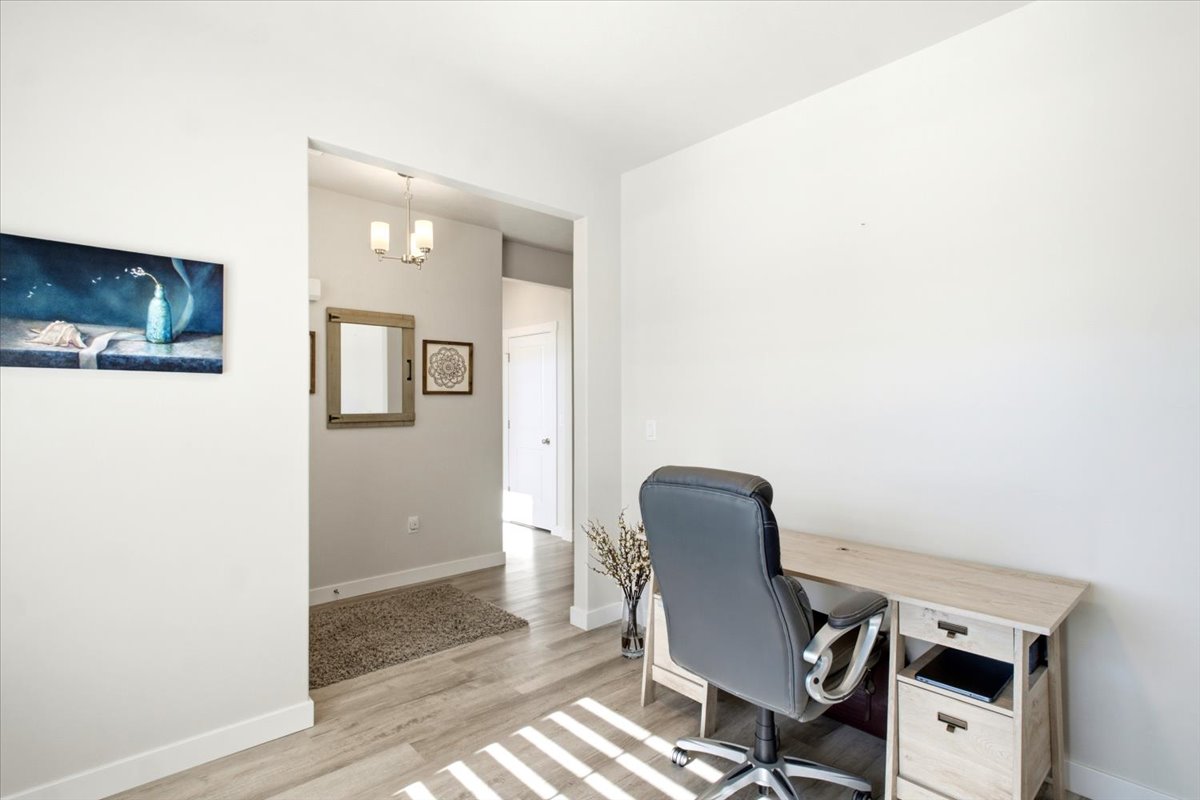 Bright interior space featuring light wood-finish flooring and white baseboards