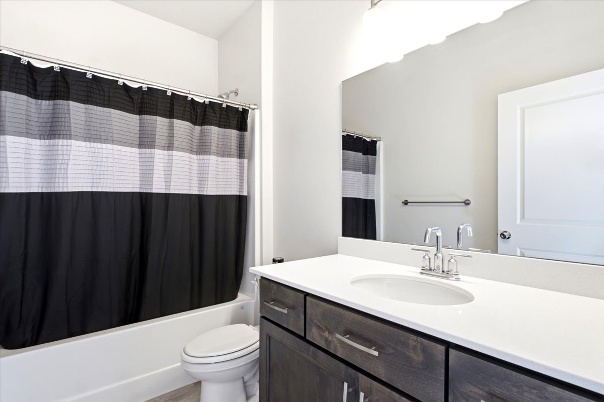 Vanity featuring a white countertop with an undermount sink and chrome faucet