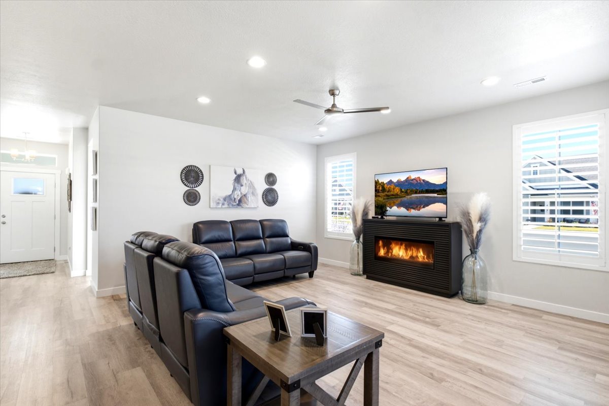 Open concept living area featuring light wood-finish flooring, recessed lighting, and a modern ceiling fan