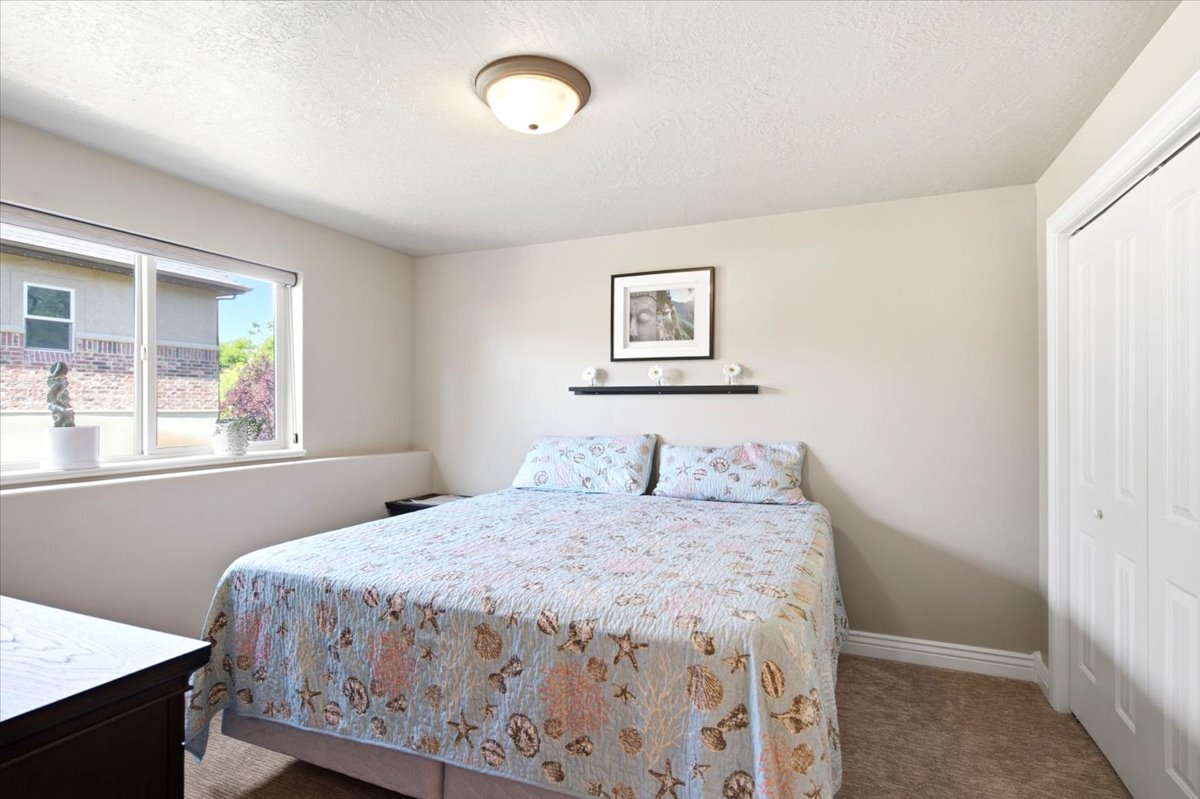 Bedroom featuring carpet flooring, a multi-pane window, and a built-in closet with bi-fold doors
