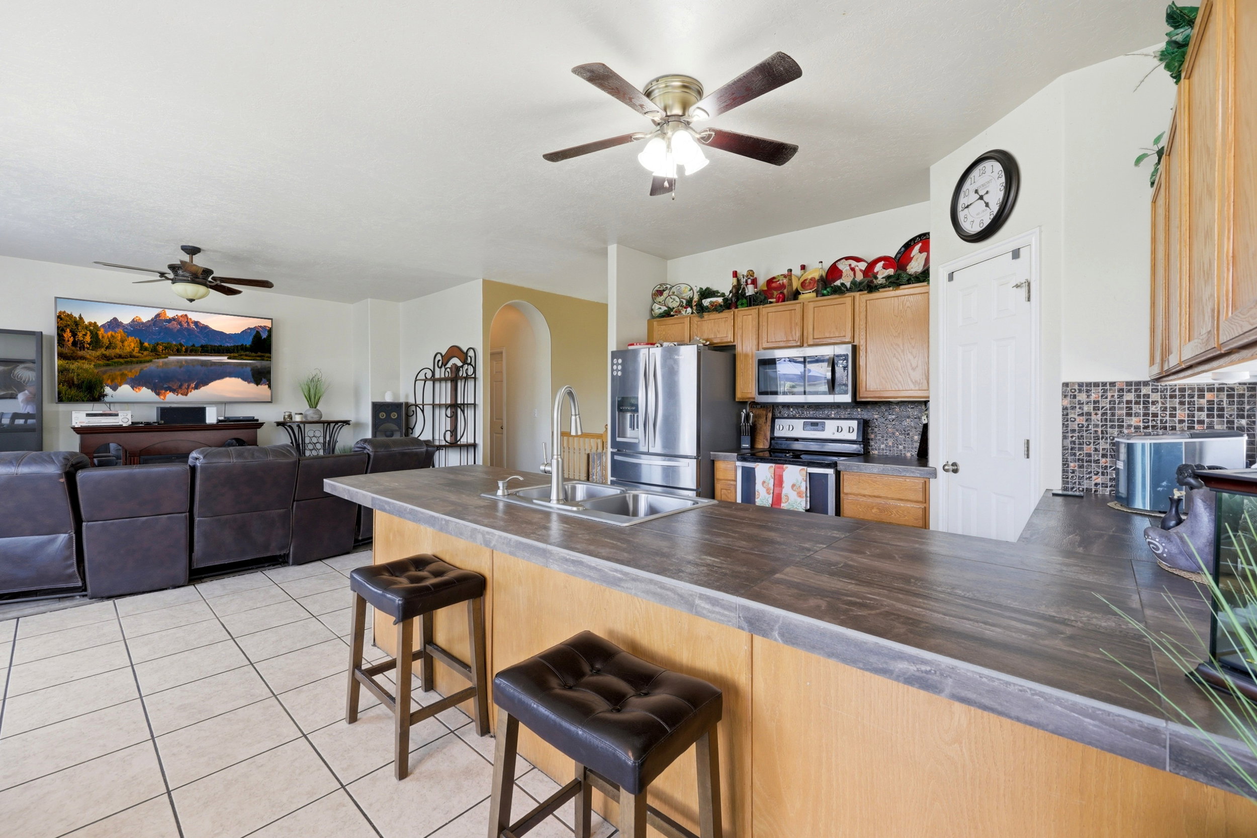Kitchen with wood-finish cabinetry, stainless steel appliances, and a mosaic tile backsplash
